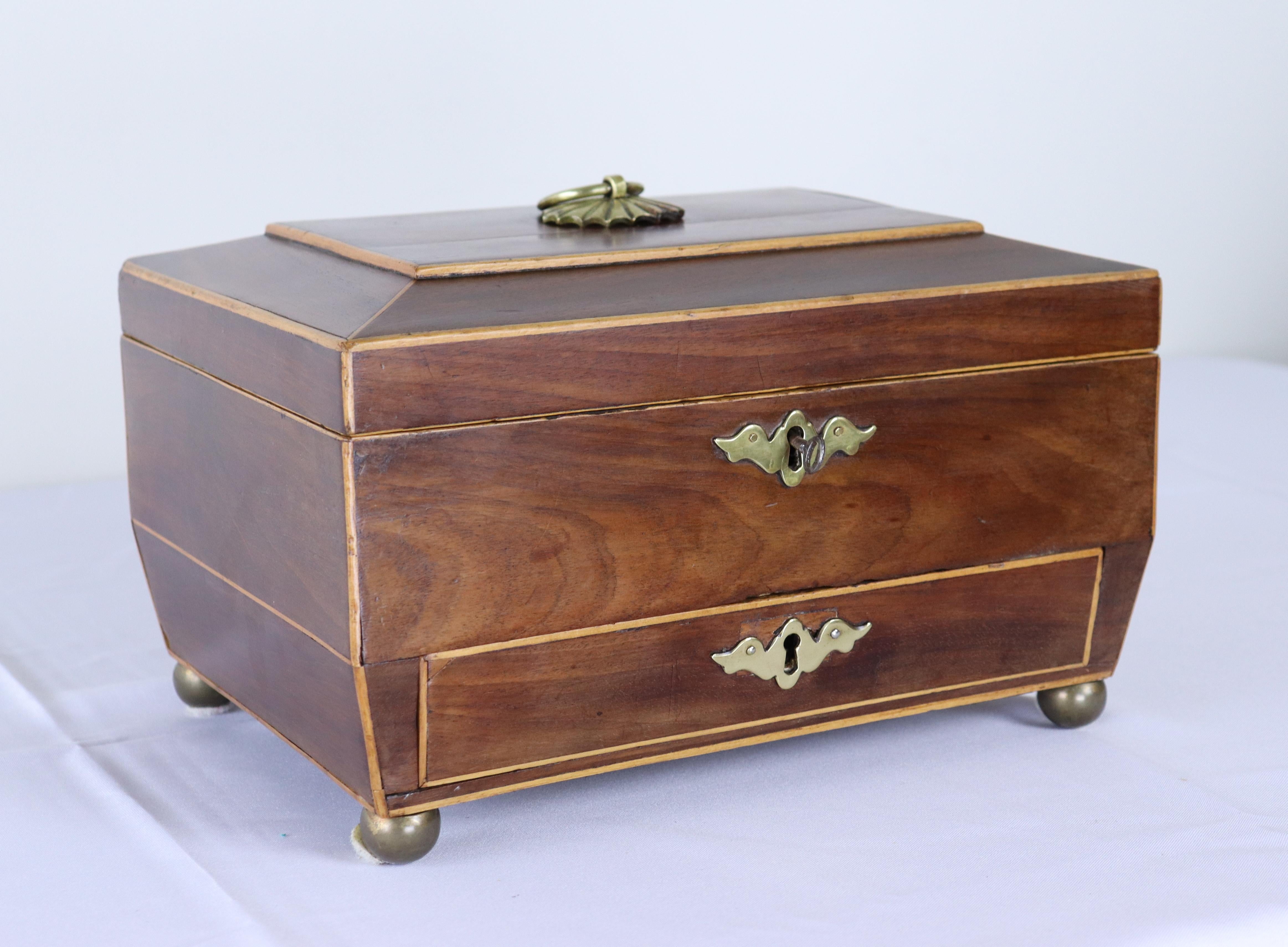 A stately sarcophagus shaped mahogany jewelry box with satinwood stringing and a hidden lower drawer.  The key fits in the key hole but does not turn easily, so more decorative than anything.