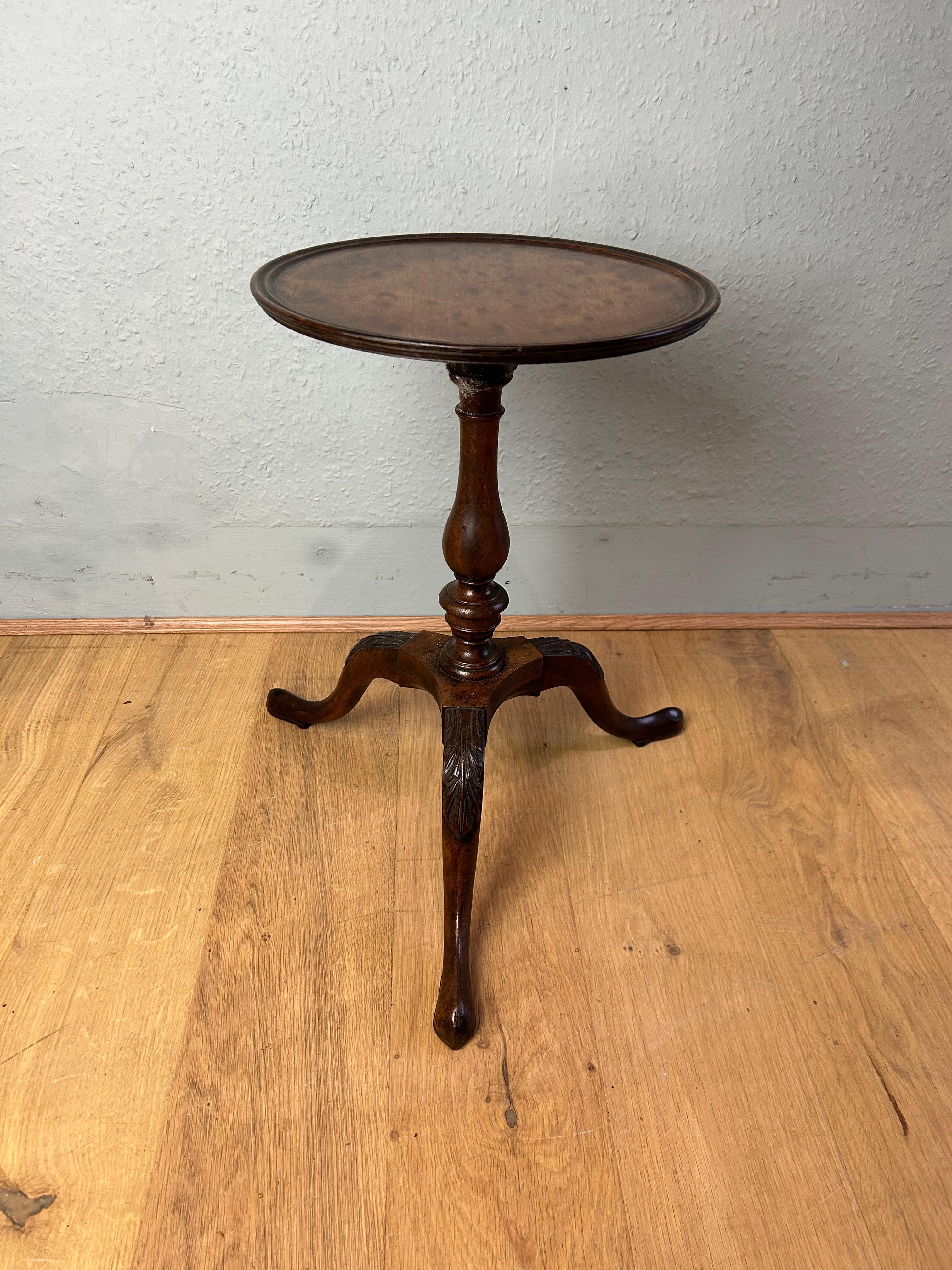 Antique English mahogany kettle stand/wine table circa 1760 with a circular dished plumb pudding mahogany top resting on a fine baluster turned column ending on a elegant cabriole leg with acanthus carving to the high knee.