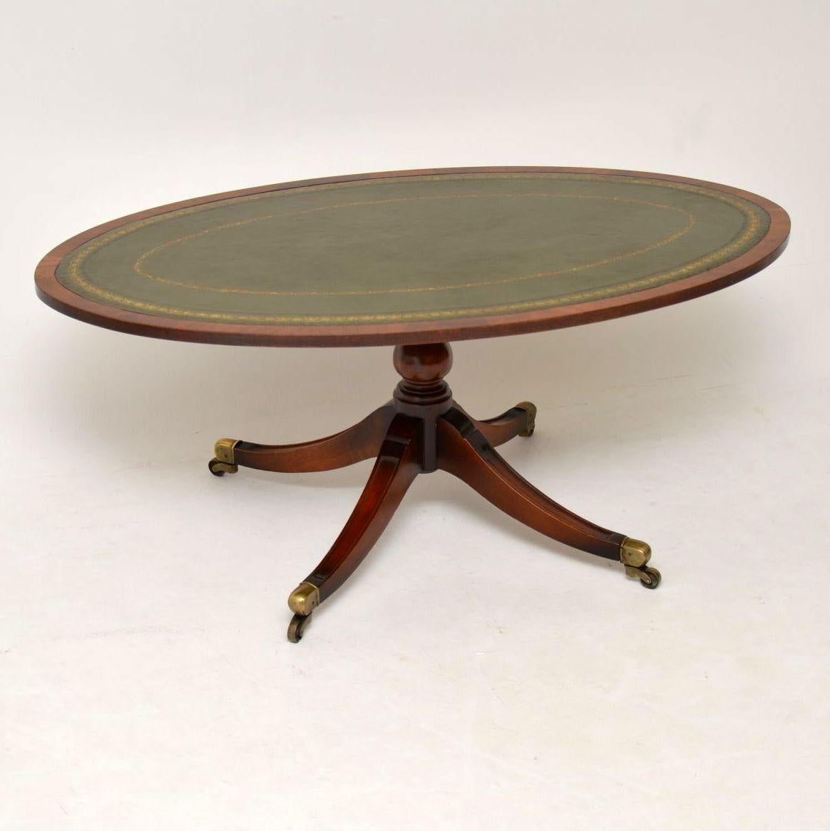 Antique Regency style mahogany coffee table with a tooled leather oval top. It’s in excellent condition and dates to around the 1930s-1950s period. It’s very sturdy and sits on a boldly turned pedestal with four sabre legs and brass capped casters.