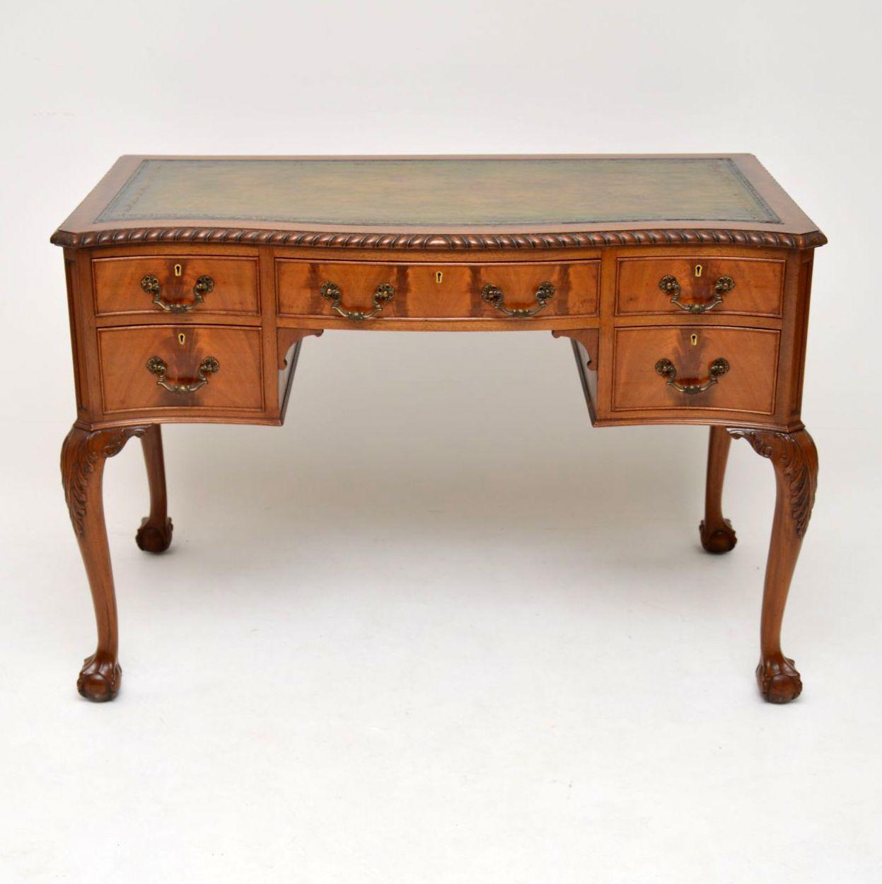 Fine quality antique Chippendale style leather top mahogany desk dating from circa 1900-1910 period and in excellent condition. It has a hand colored tooled leather writing surface with a gadrooned edge going all the way around. This desk has a