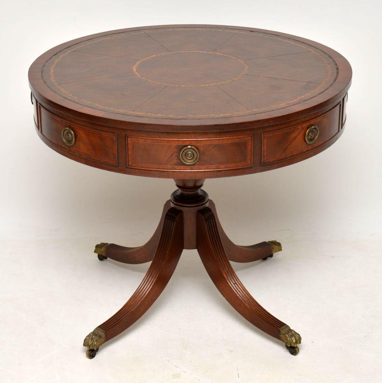 This antique leather top mahogany drum table is very fine quality & is in great condition. It has a tooled leather inset top, four drawers & four dummy drawers with original brass handles & sits on a baluster pedestal on quadruple reeded legs with