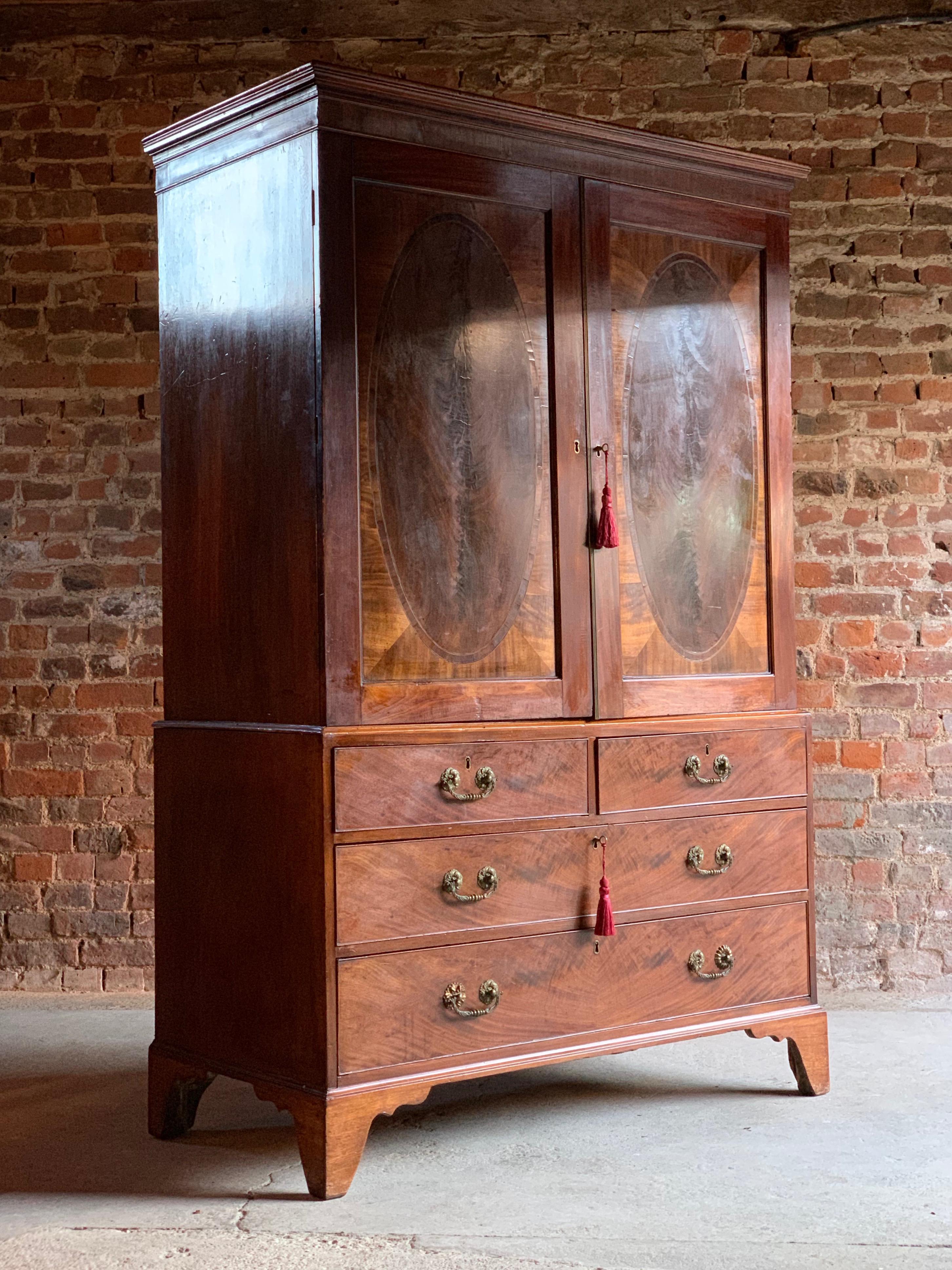 Antique 18th century George III mahogany linen press, circa 1780.

A magnificent antique 18th century George III mahogany linen press, circa 1780, the molded cornice above two oval ebony banded and paneled doors, enclosing three shelves and