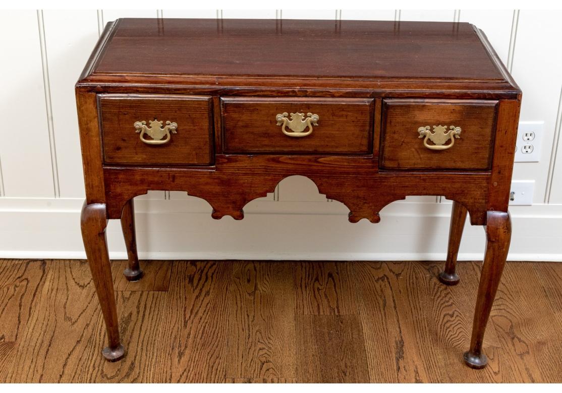 Un raffinato Lowboy di inizio secolo con cassetti costruiti a coda di rondine, pesanti tiranti originali a pipistrello in ottone, grembiule elaboratamente intagliato e gambe primitive Cabriolet con piede Queen Anne.

Dimensioni: 38,25