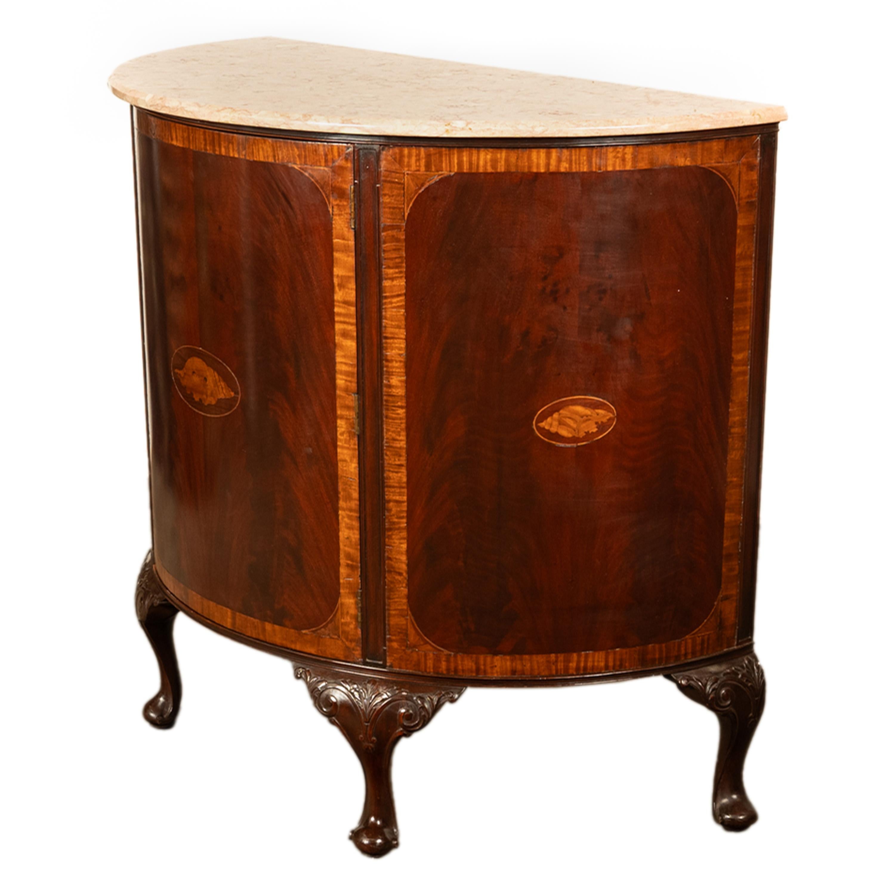 A fine antique marquetry inlaid & marble topped flame mahogany demi-lune cabinet, circa 1900.
This very elegant antique demi-lune cabinet with a cream and caramel veined marble top, the case is made of the finest figured mahogany & has a single