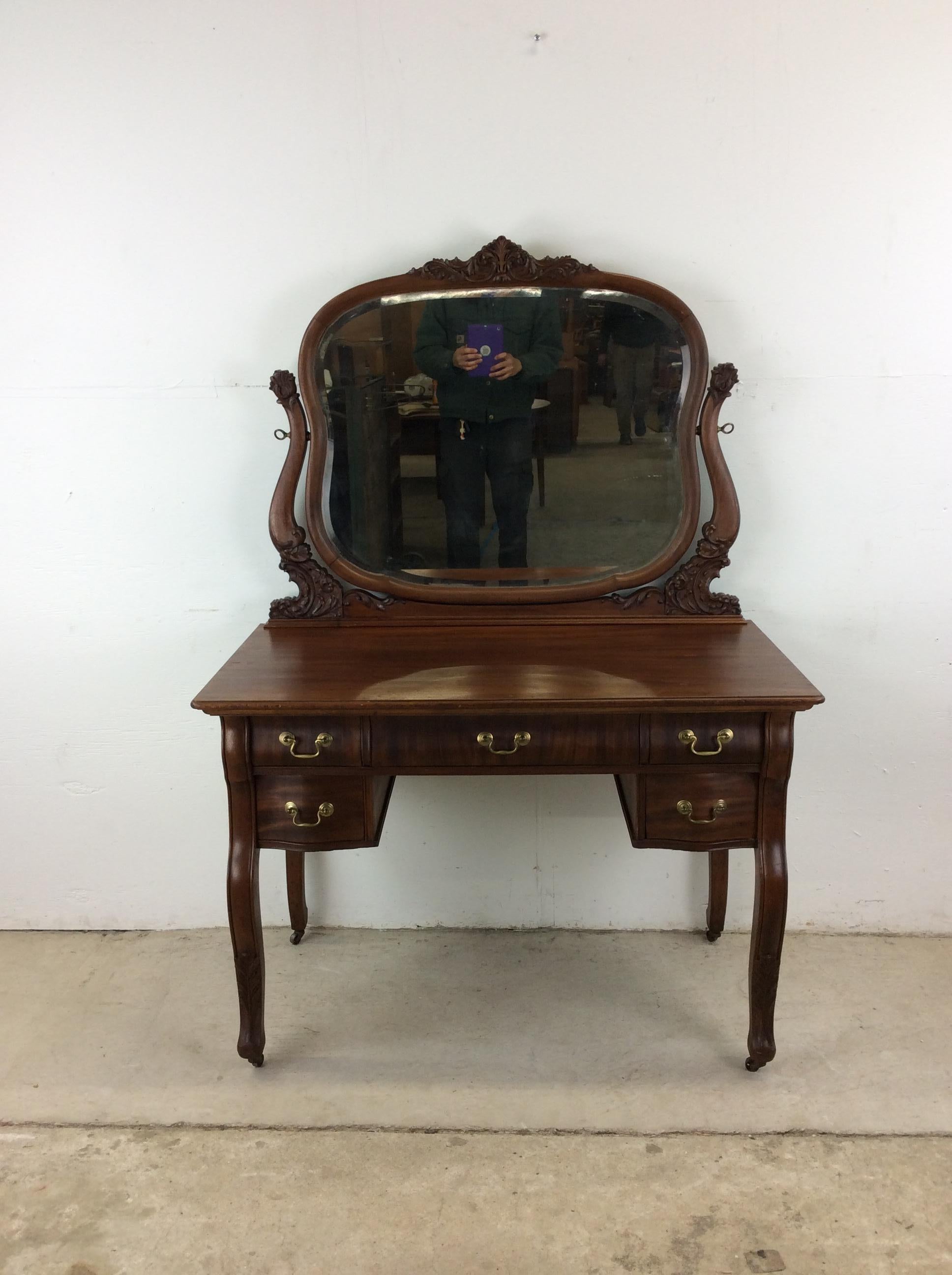 Questo antico mobiletto a specchio di Wood Wood presenta una struttura in legno massiccio, una bella impiallacciatura in mogano con finitura nuova, cinque cassetti a coda di rondine con ferramenta in ottone, specchio montato con supporti in legno