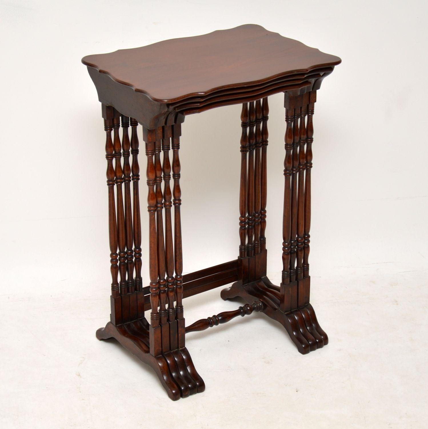 Antique solid mahogany nest of four tables in excellent condition, dating from the 19th century. The tops are shaped all the way around and the tall legs are beautifully turned. There are cross stretchers at the base which help keep them more stable
