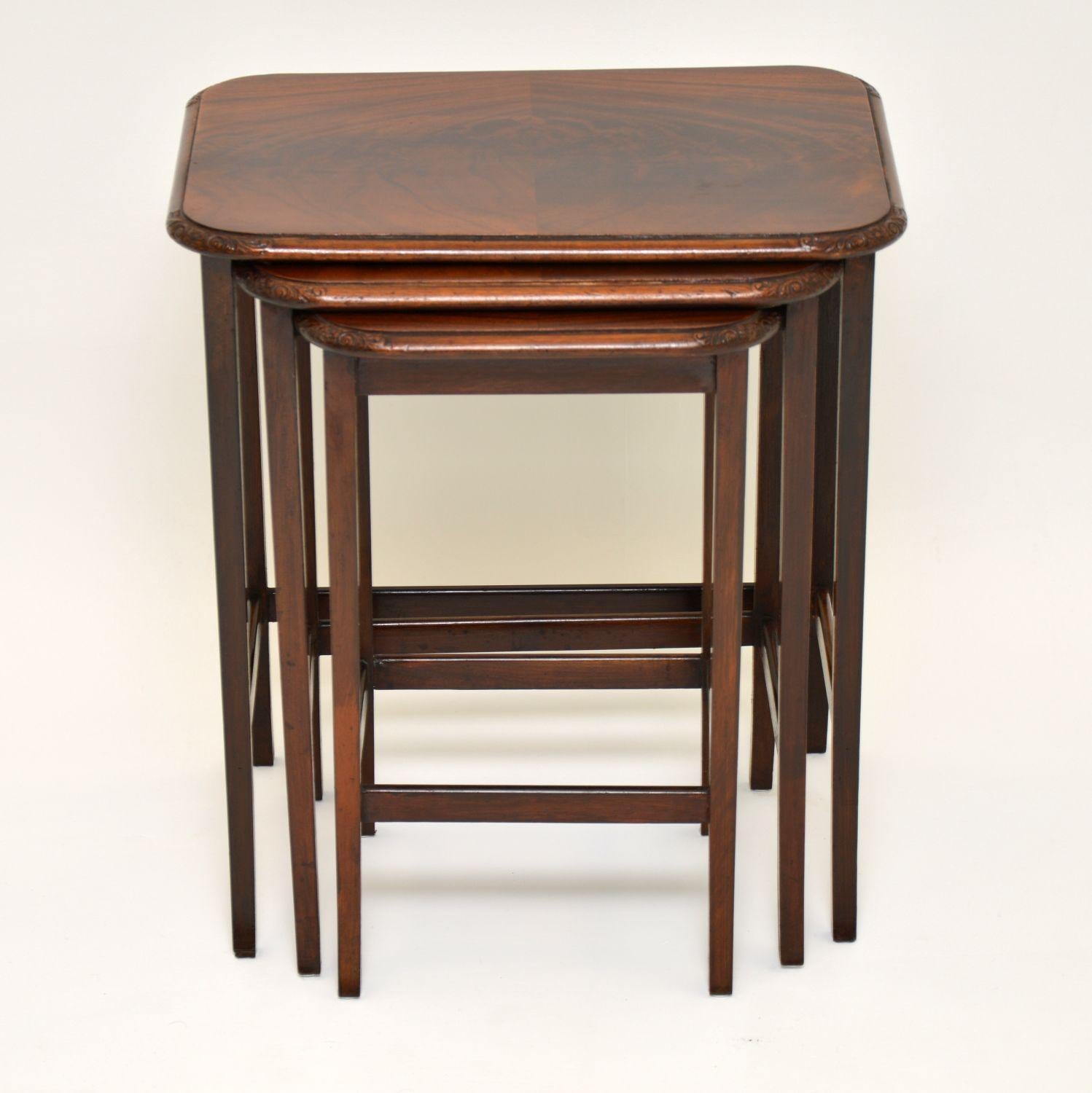 Small antique mahogany nest of tables with flame mahogany tops, all in good condition and dating from circa 1910 period. The top corners are carved and the legs have cross stretchers between which give them more stability.

Measures: Width 19