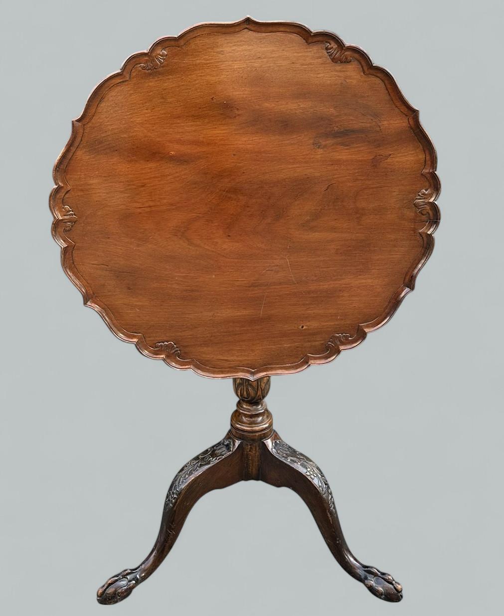A Very Imposing example of an English well figured Mahogany Georgian Style Circular snap-top Occasional Table of medium proportions. Circa 1900. 

The tilt up circular hand carved dished border top with circular roundels, on turned acanthus leaf