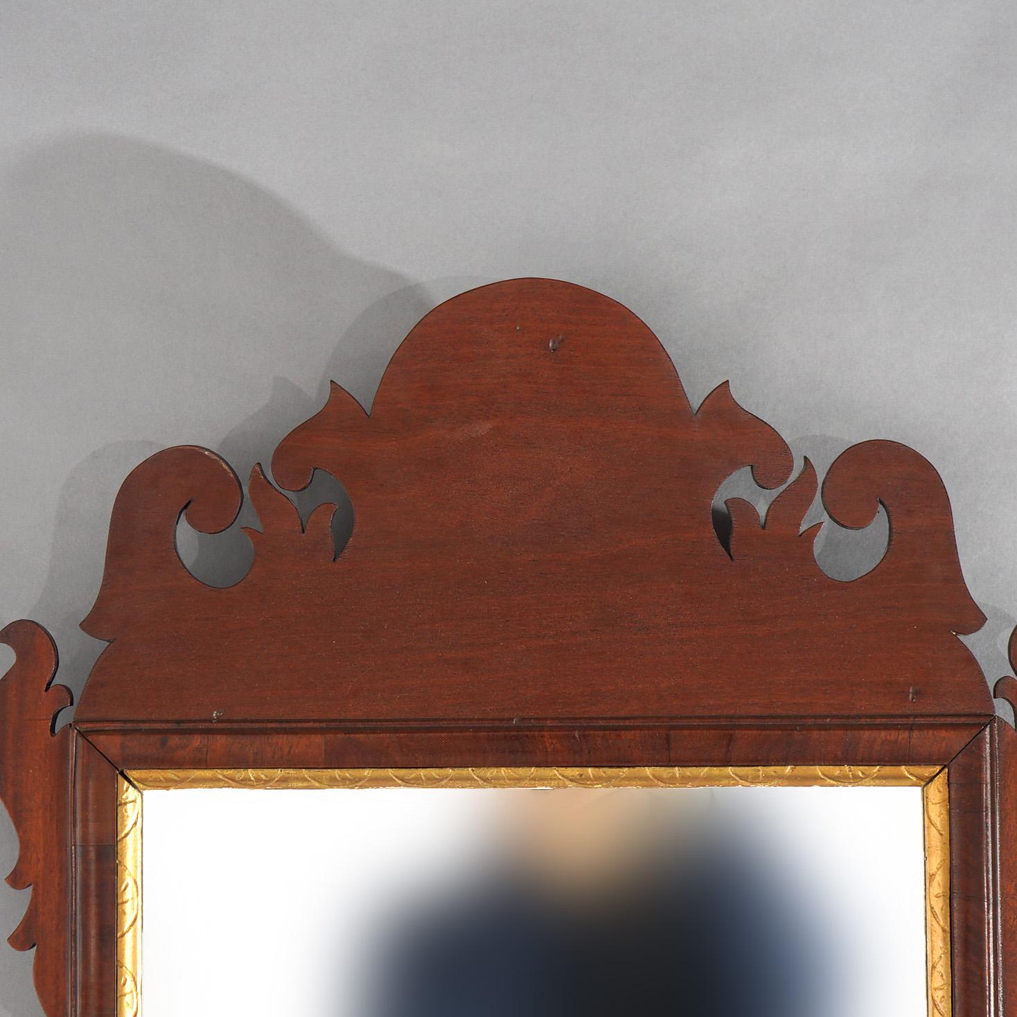 An antique Chippendale wall mirror offers mahogany frame with scrolled bordering and gilt trim, 19th century

Measures- 43.5''H x 21''W x 2''D; 14.5'' x 25.5'' sight 