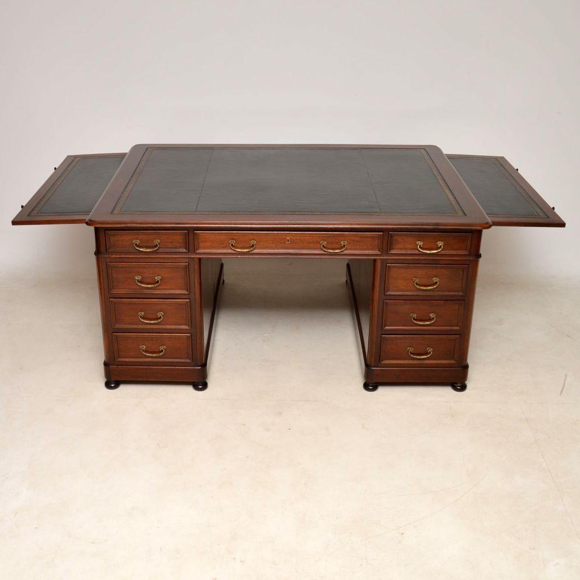 Fine quality antique mahogany partners desk with the original tooled leather writing surface and two pull-out slides also with the same tooled leather. It’s a great looking piece and a good sized desk with drawers on both back and front. The drawers