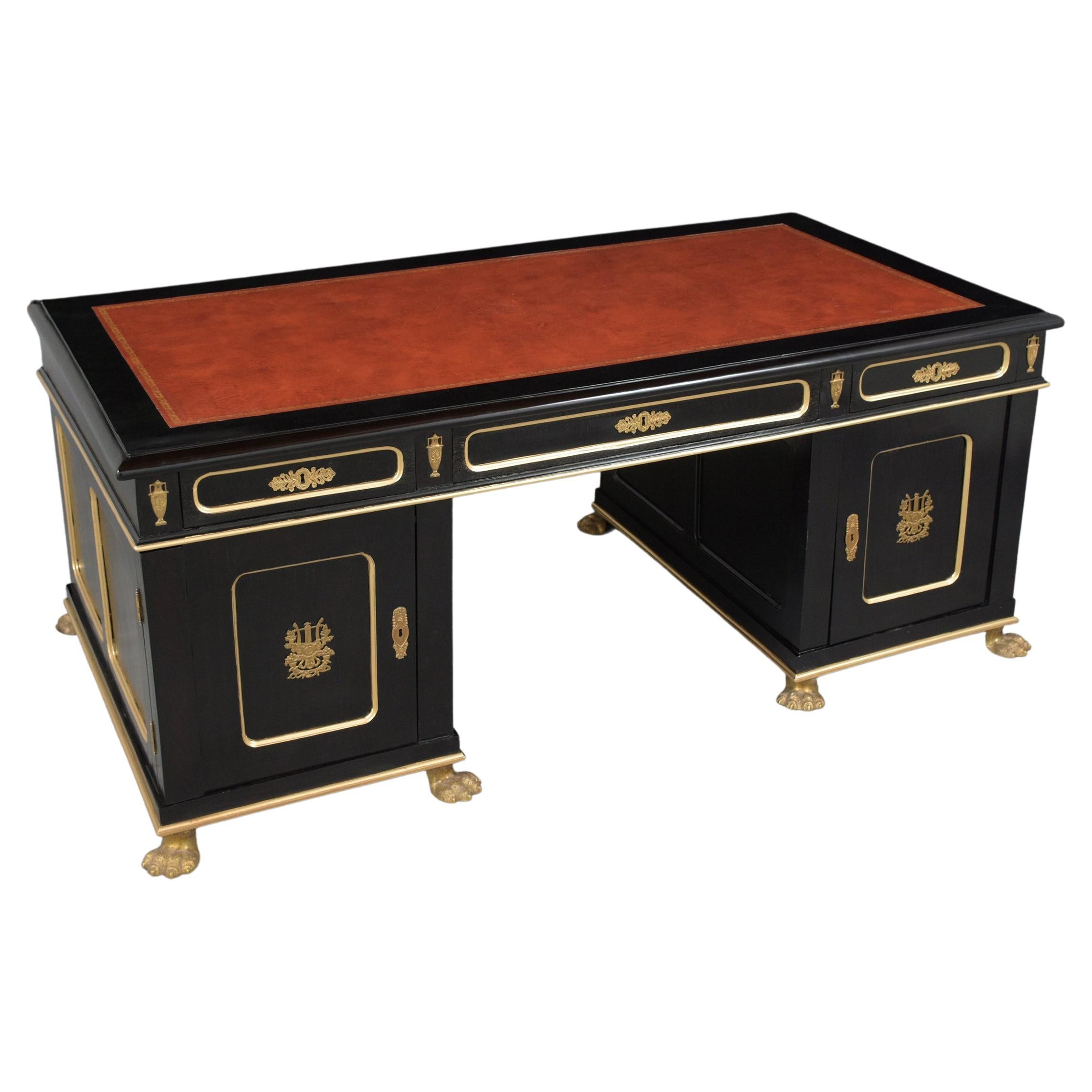 An extraordinary antique empire partners desk in excellent condition is handcrafted out of mahogany wood and has been completely restored by our professional craftsmen team. This executive desk is eye-catching and features beautiful brass ornaments