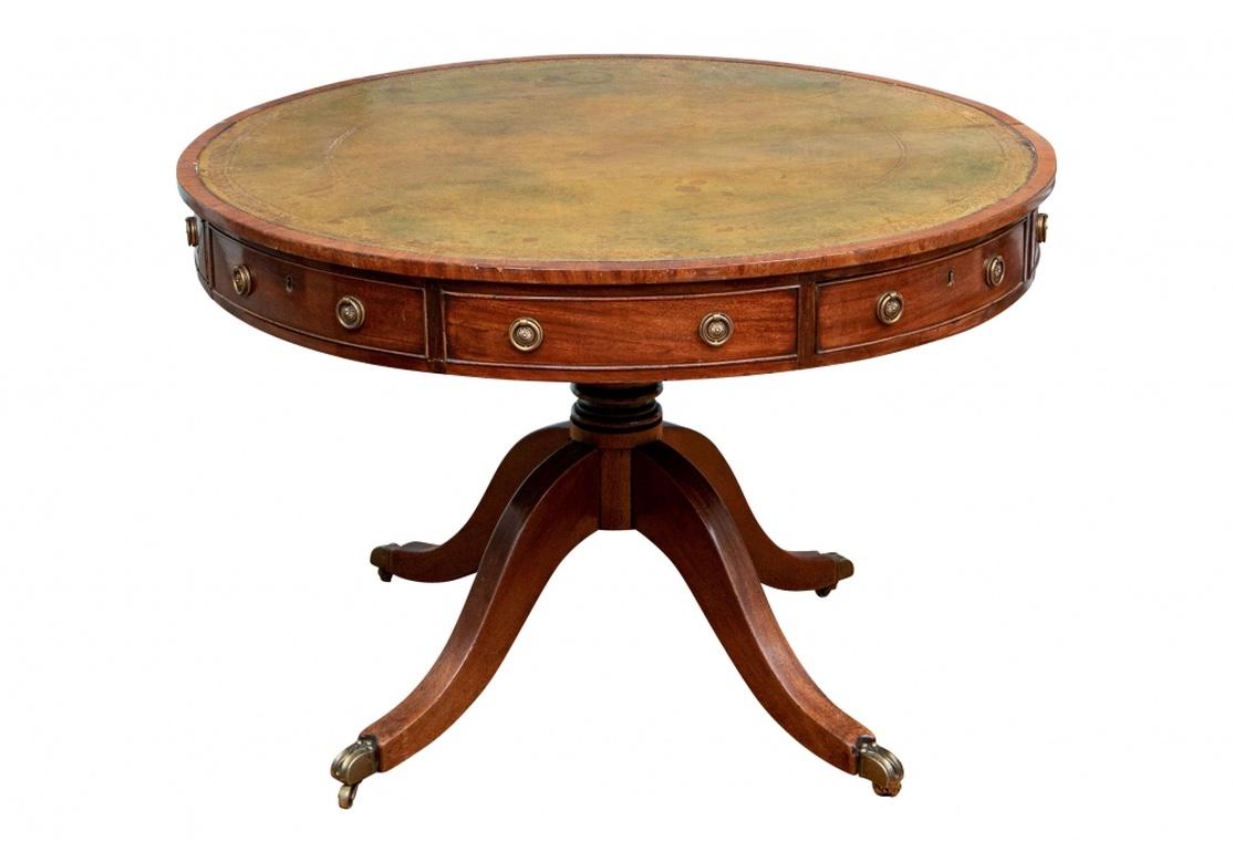 Large round table with four working drawers alternating with four faux drawers. The working drawers with brass keyholes (three are locked). With a gilt embossed green leather revolving top. Raised on a Fine turned support on four splayed legs with