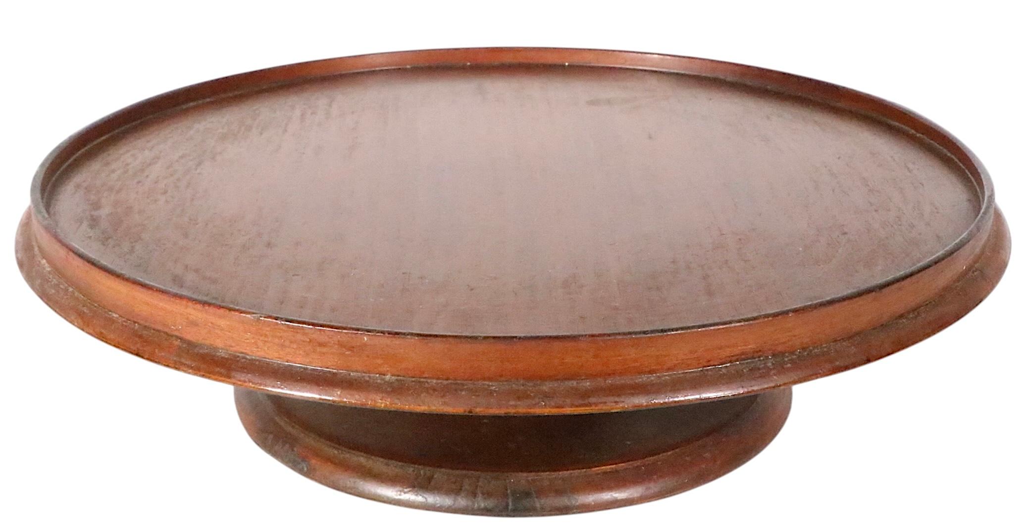 Rotating Lazy Susan serving platform, made  in the U.K. circa 1880/1920. This charming piece features a disk form top with surrounding rim, mounted on a waisted from pedestal base. This example is in very good, clean, original, ready to use