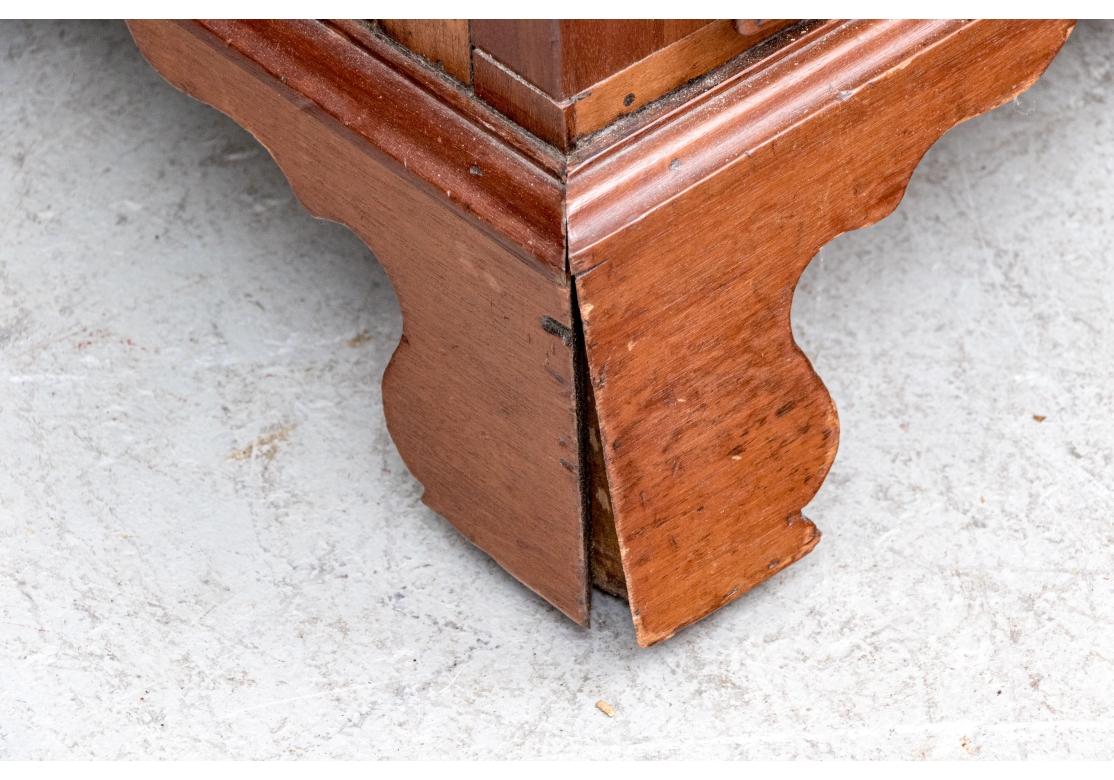 Un mueble secreter clásico finamente elaborado en caoba. Con un alto frente de caída que se abre a un interior equipado con tres cajones pequeños encima y debajo de los huecos serpenteantes. La superficie de escritura está cubierta de fieltro verde