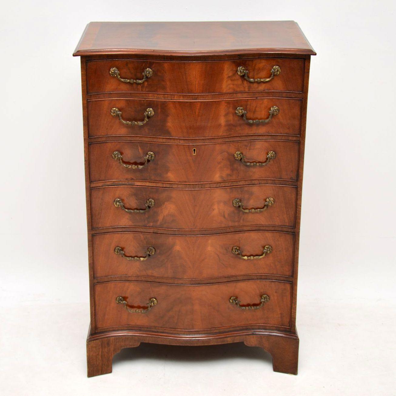 This antique mahogany serpentine fronted chest of drawers is of very fine quality & I would date it to around the 1920-30’s period. The top & the front are a vivid flame mahogany, with cross banded top edge & a beautiful grain pattern running all