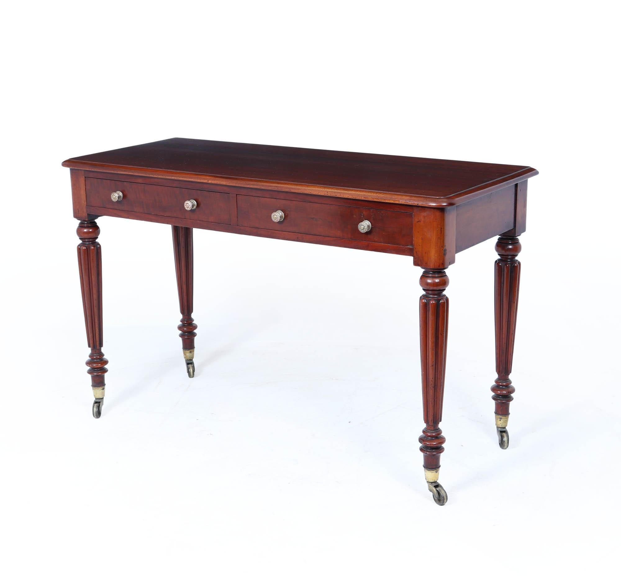 A handsome and versatile late William IV to early Victorian side table, crafted in solid mahogany with turned and fluted legs, dating to around 1840. This refined piece showcases the transition between Regency formality and early Victorian