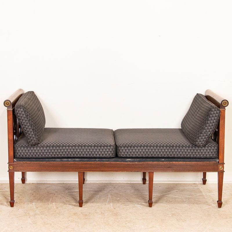 This classic Swedish sofa has refined lines and simple gold accent medallions which add to the understated elegance of the piece. Also considered a settee or chaise lounge sofa, the seat and cushions may easily be re-upholstered with modern fabric.