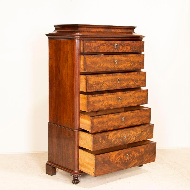 The mahogany veneer is stunning in this tall chest of 7 drawers. The highboy is built in 2 sections making it easier to move/install and rests on carved feet. The drawers work and have 3 keys to use as pulls. This traditional 