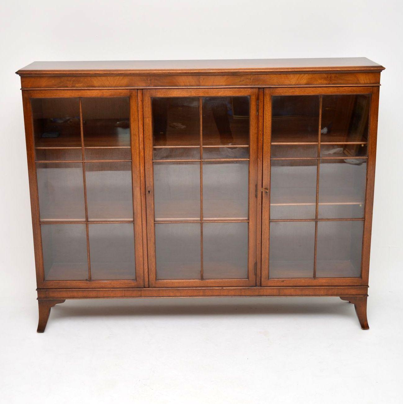 Antique three door bookcase in mahogany dating to around the 1950s period and in good original condition. It has astral-glazed doors, with adjustable bookshelves inside and sits on splayed feet. There's one single compartment on the right and a