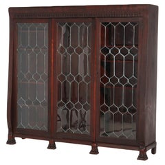 Librería antigua de caoba con tres puertas de cristal emplomado y patas de garra talladas C1900
