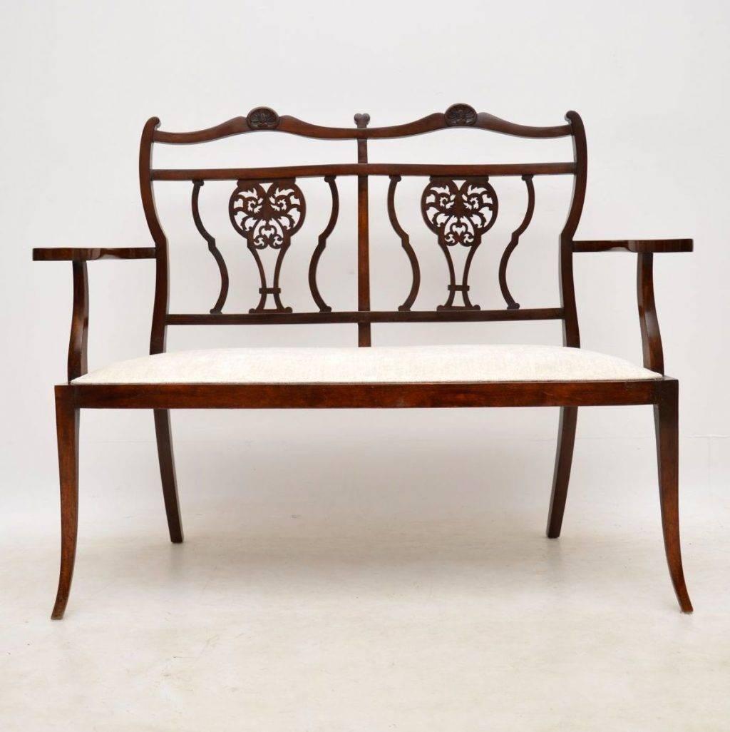 Antique Edwardian mahogany two seater settee, in good condition and with a newly re-upholstered seat. This settee is very elegant with intricate carvings on the back and kick out legs. It may look delicate, but it is structurally sound and dates to