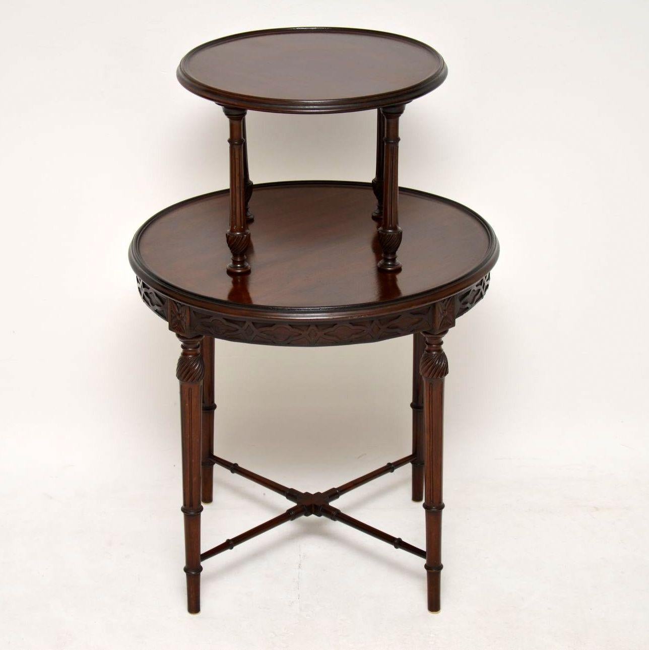 Fine quality antique Edwardian mahogany two-tiered circular table in excellent original condition and with many fine details. The top tier is supported by four turned fluted supports with spiral twists at the base. The larger bottom tier has a blind