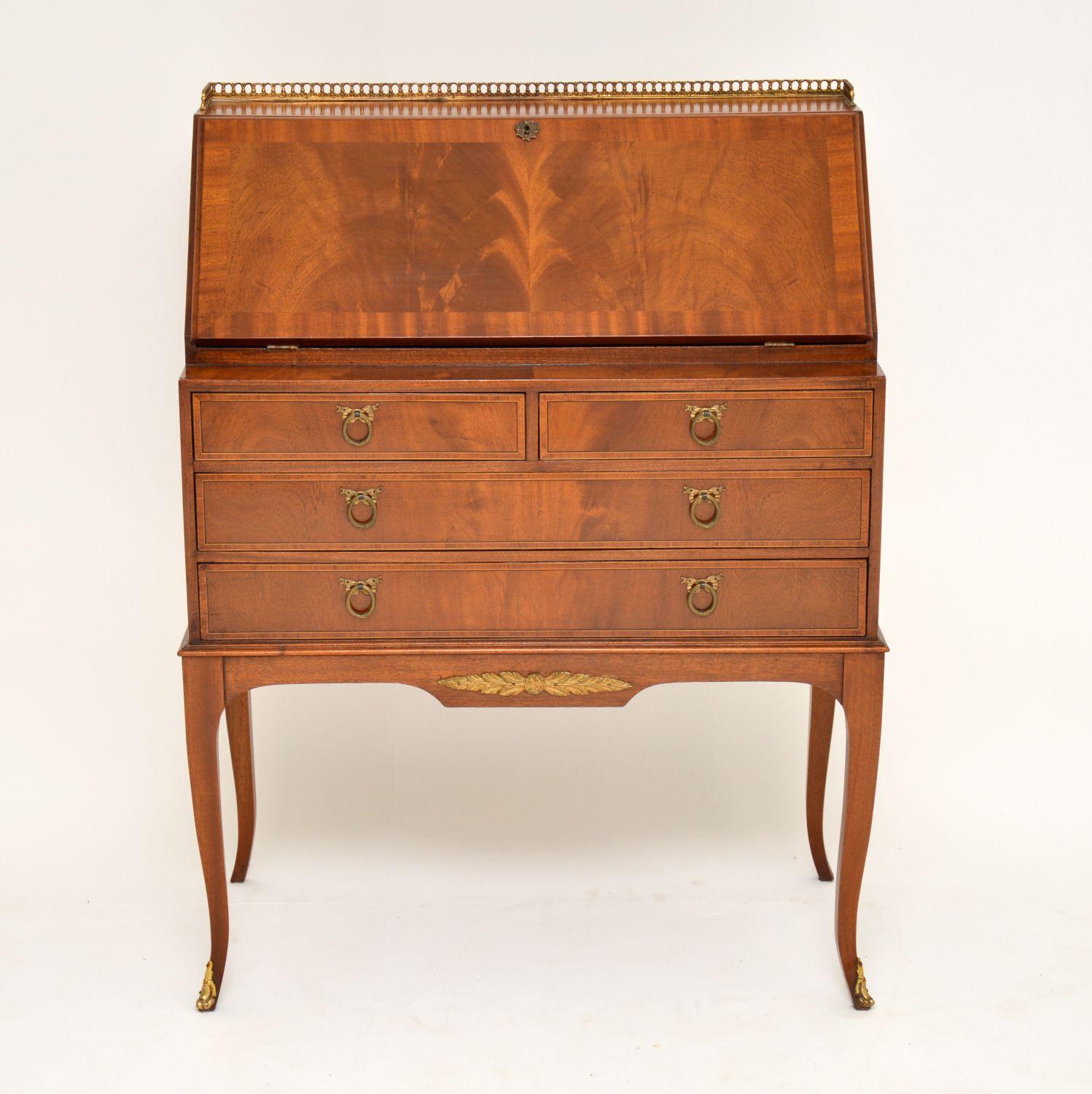 Fine quality antique mahogany bureau in good original condition, which I would date to circa 1910 period. It has a gilt metal pierced gallery on the top, plus gilt handles, mounts and feet. I think this bureau is English with a French neoclassical