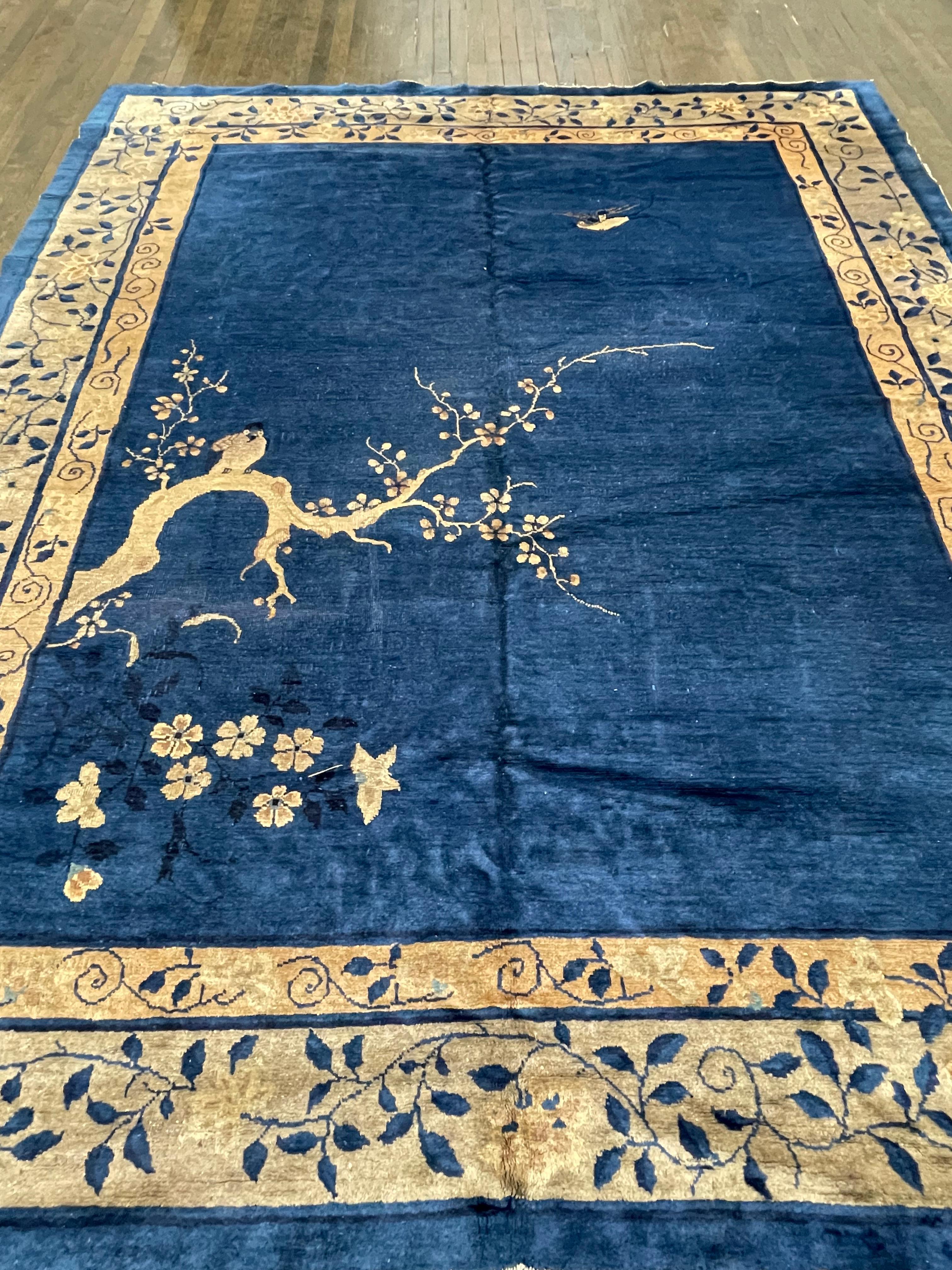 Ce tapis très rare et inhabituel est tissé à la main en Chine. Un bleu indigo uni décoré d'un grand arbre, symbole chinois de la connaissance et de la sagesse, fait que ce tapis ressemble davantage à une peinture tissée pour le sol. Véritable art