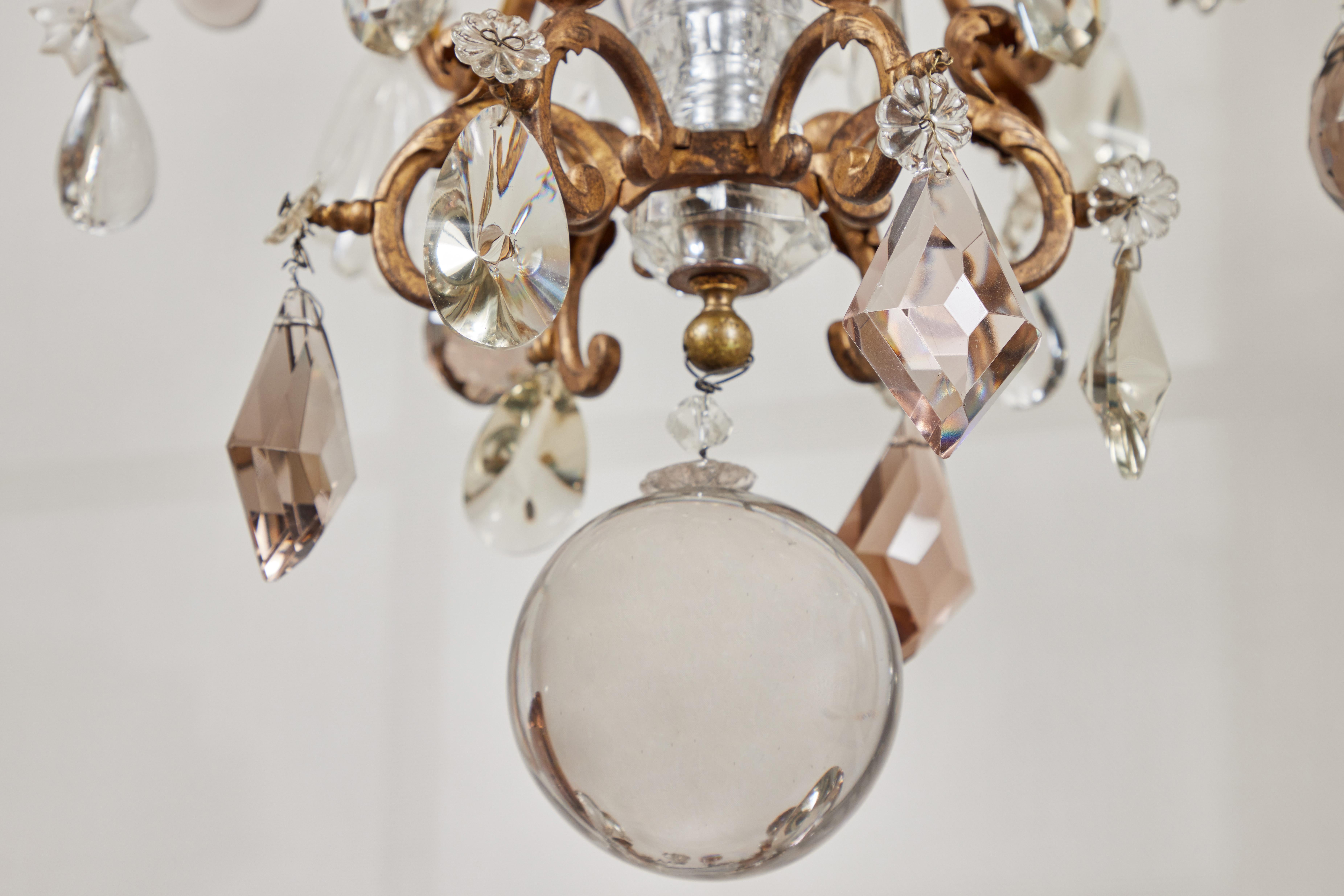 An elegant, detailed, 19th c. French chandelier featuring a scrolling, foliate form gilt bronze carriage embellished with a variety of clear and amber crystals. Made by the renowned Maison Baguès in Paris.