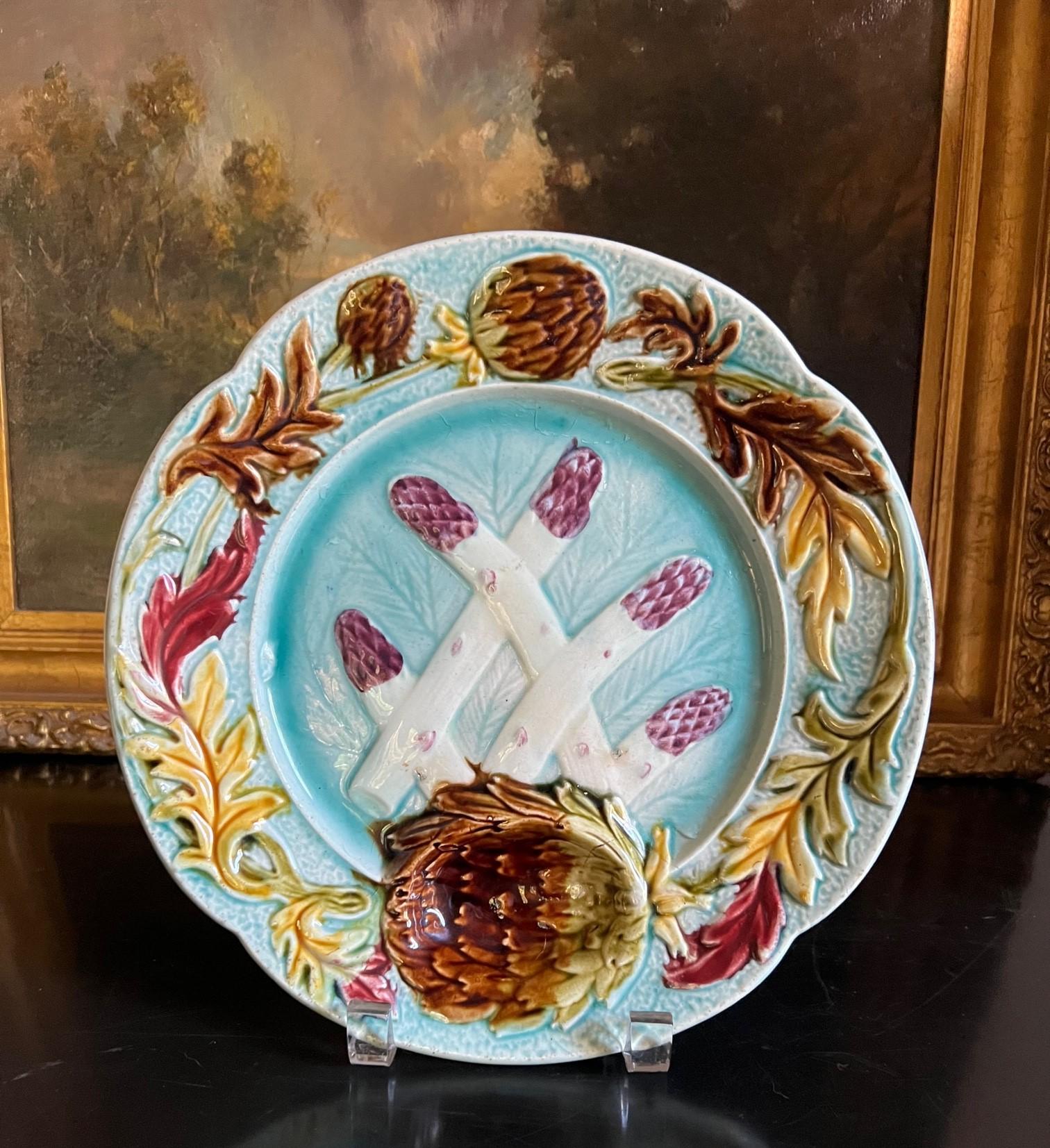 Assiette à asperges et artichauts en majolique française aux couleurs vives, fabriquée dans la manufacture Orchies à la fin des années 1800. L'assiette a un bord festonné avec des fleurs d'artichaut et des feuilles de couleur automnale, la plus