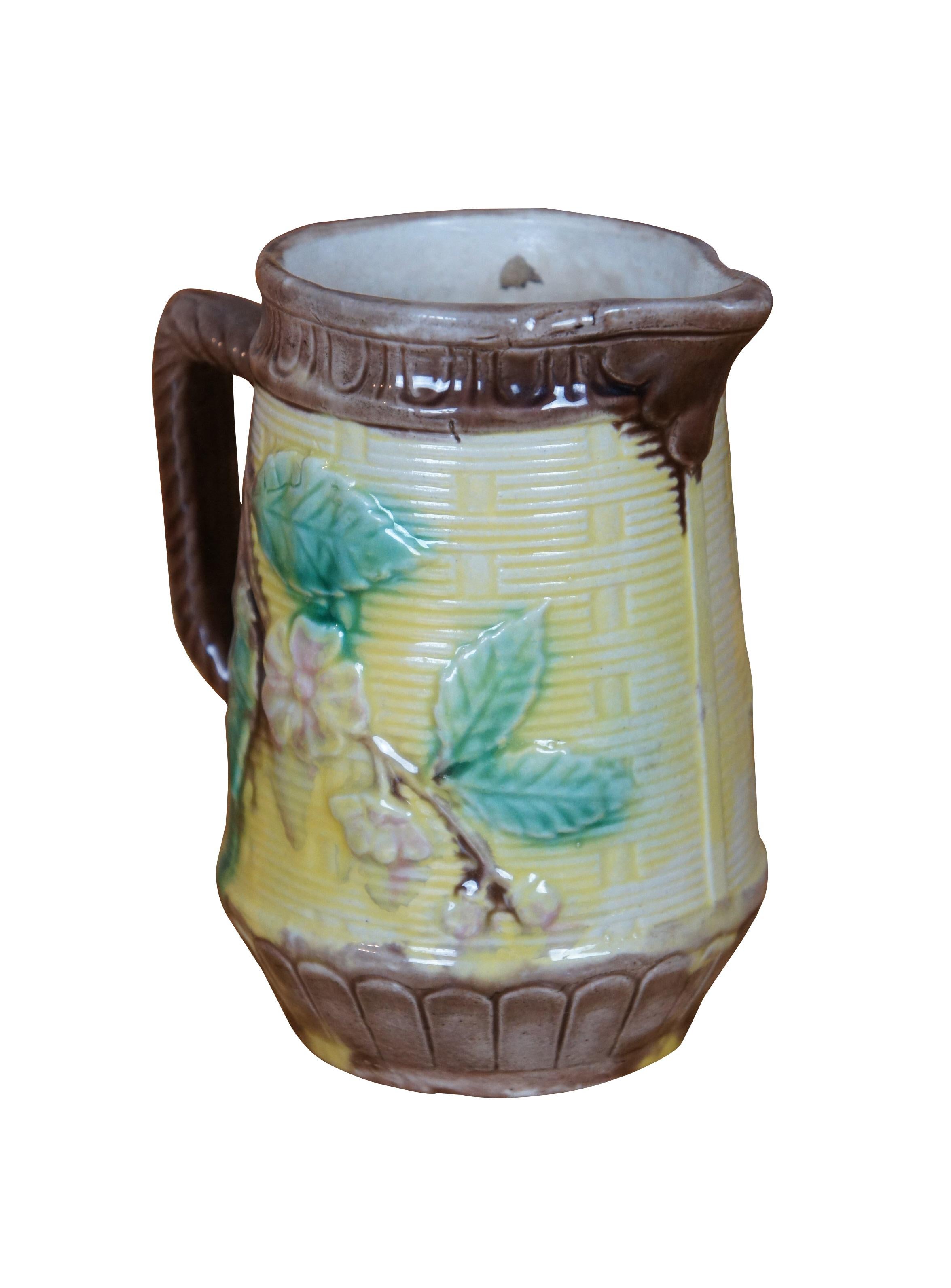Antique Majolica creamer pitcher or jug featuring a yellow and brown basketweave motif with dogwood flower accents, twisted handle and acanthus spout.

Dimensions:
5