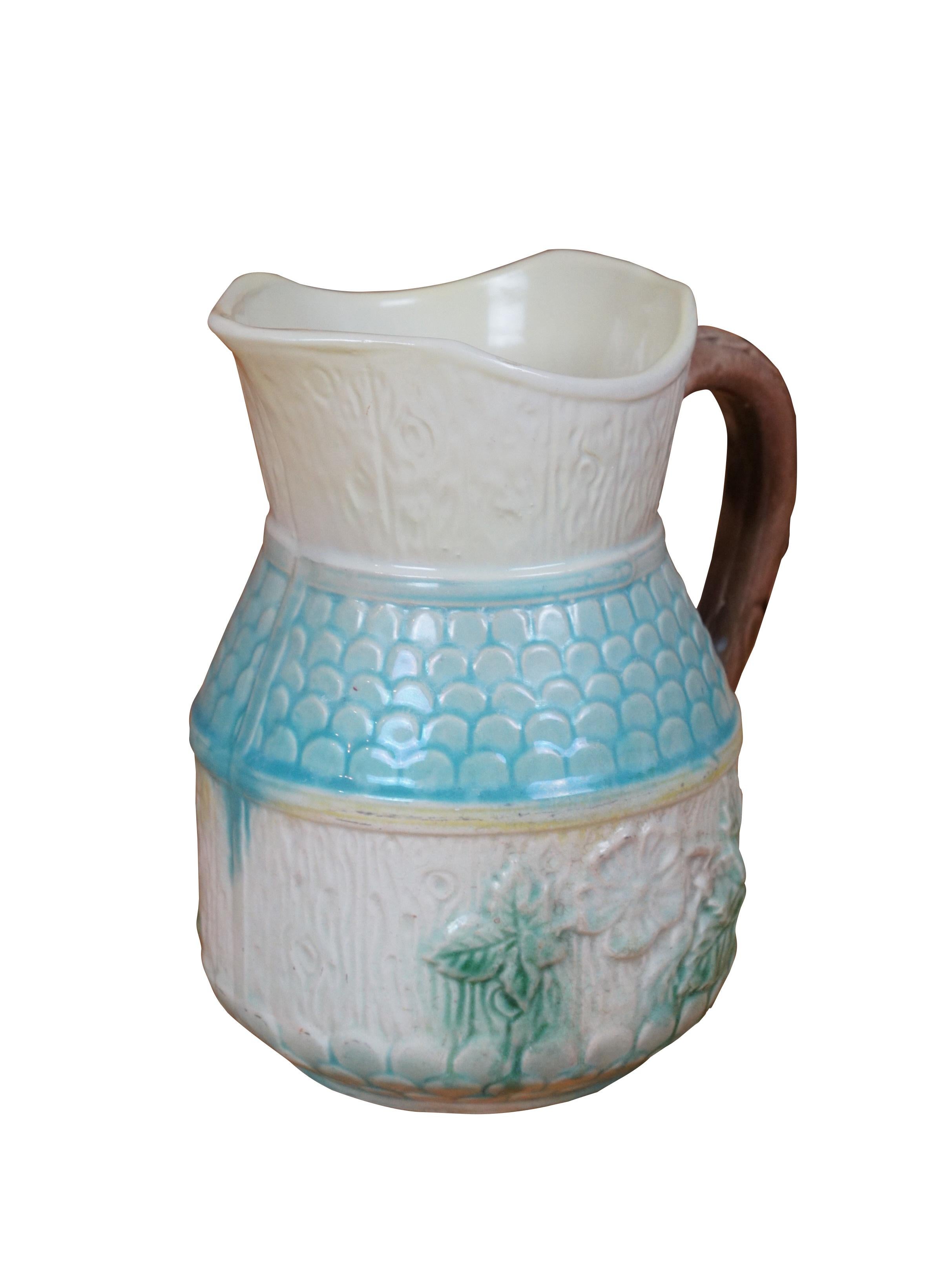 Antica lattiera in maiolica con motivo di fattoria con venature del legno, tegole, rose selvatiche e manico d'acanto.

Dimensioni:
6,25
