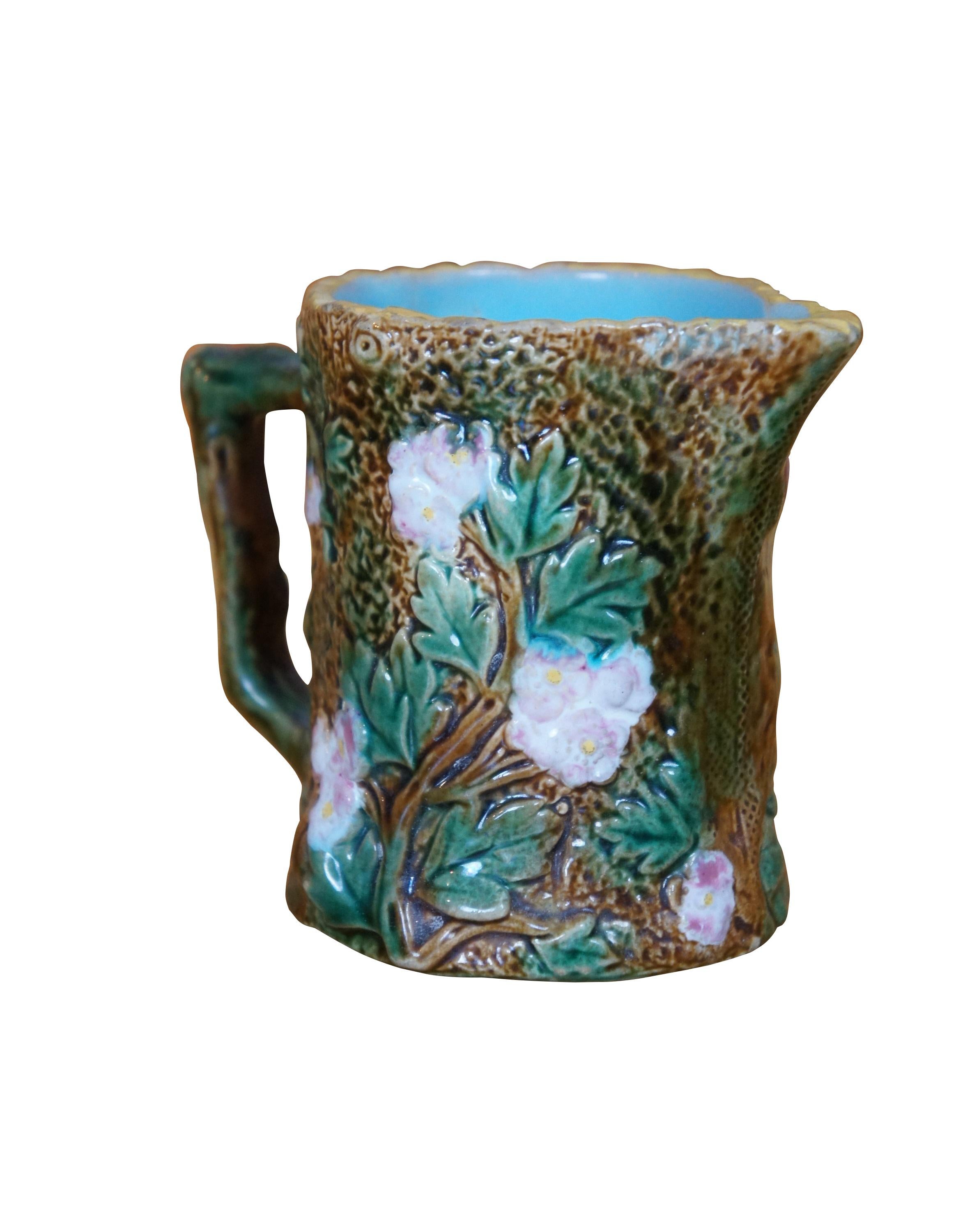 Antica lattiera in maiolica di George Jones con un tema rustico di alberi e cortecce con fiori di maggiociondolo e manico a forma di ramo.  Marcato 3368.

Le maioliche di George Jones sono uno dei nomi più ambiti della maiolica. È molto facile