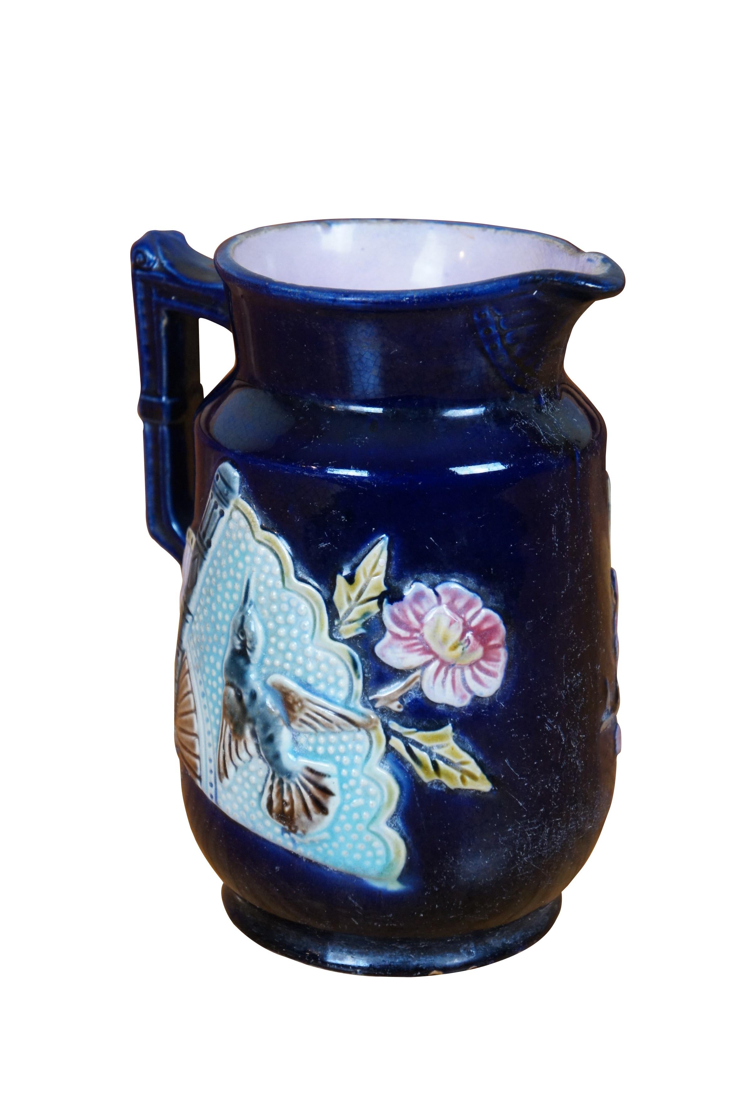 Antique Majolica creamer pitcher / jug featuring a deep cobalt blue glazed ground accented with a Chinese hand fan with hummingbirds and flowers.  Attributed to Shorter & Boulton.  Most of Shorter & Boulton designs had a strong Asian influence. One