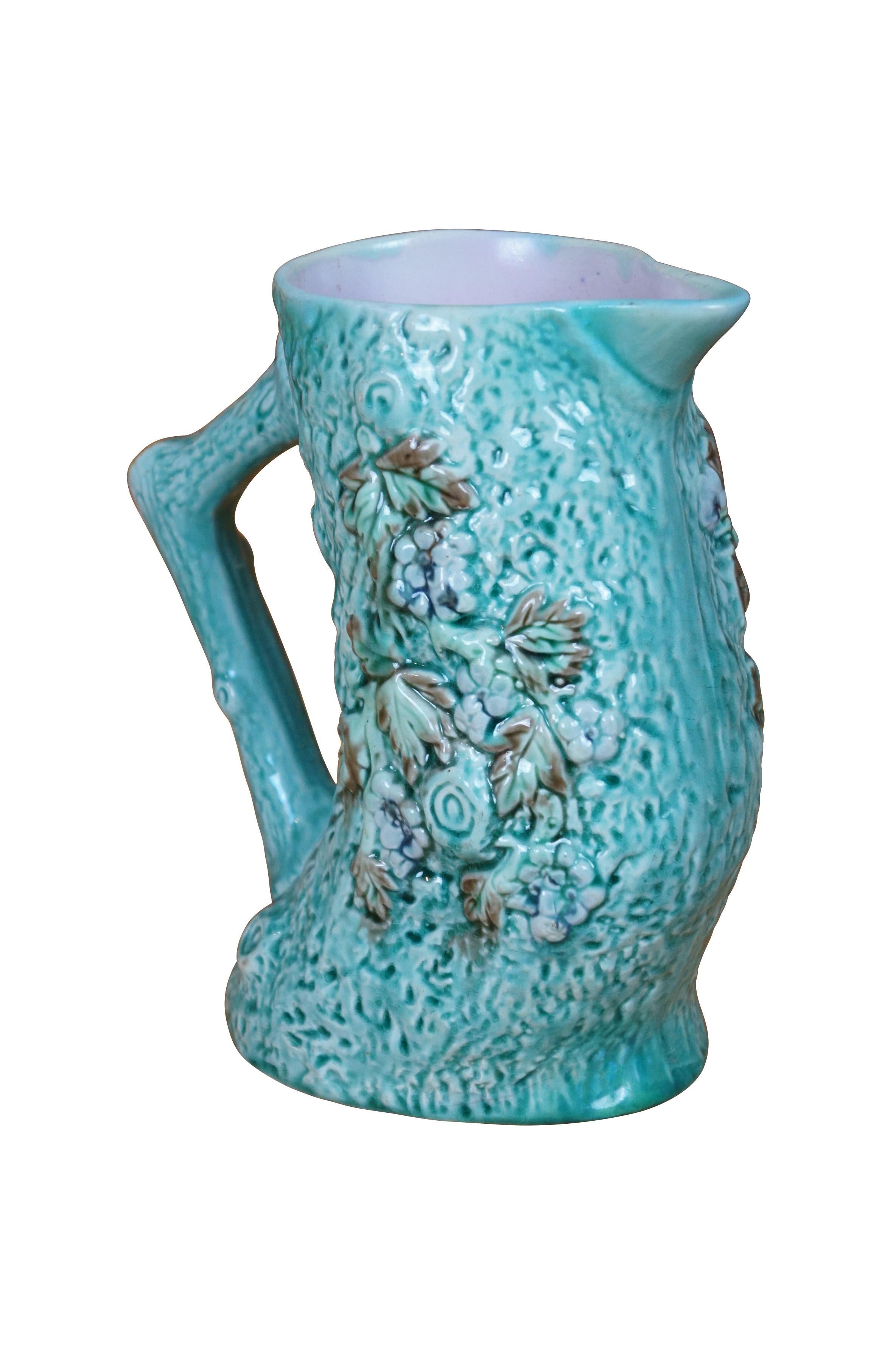 Antique Majolica Adirondak style bentwood tree trunk / log / branch creamer pitcher / jug / carafe featuring a turquoise glaze over textured bark motif with flowers / leaves and purple lavender interior.

Dimensions :
8