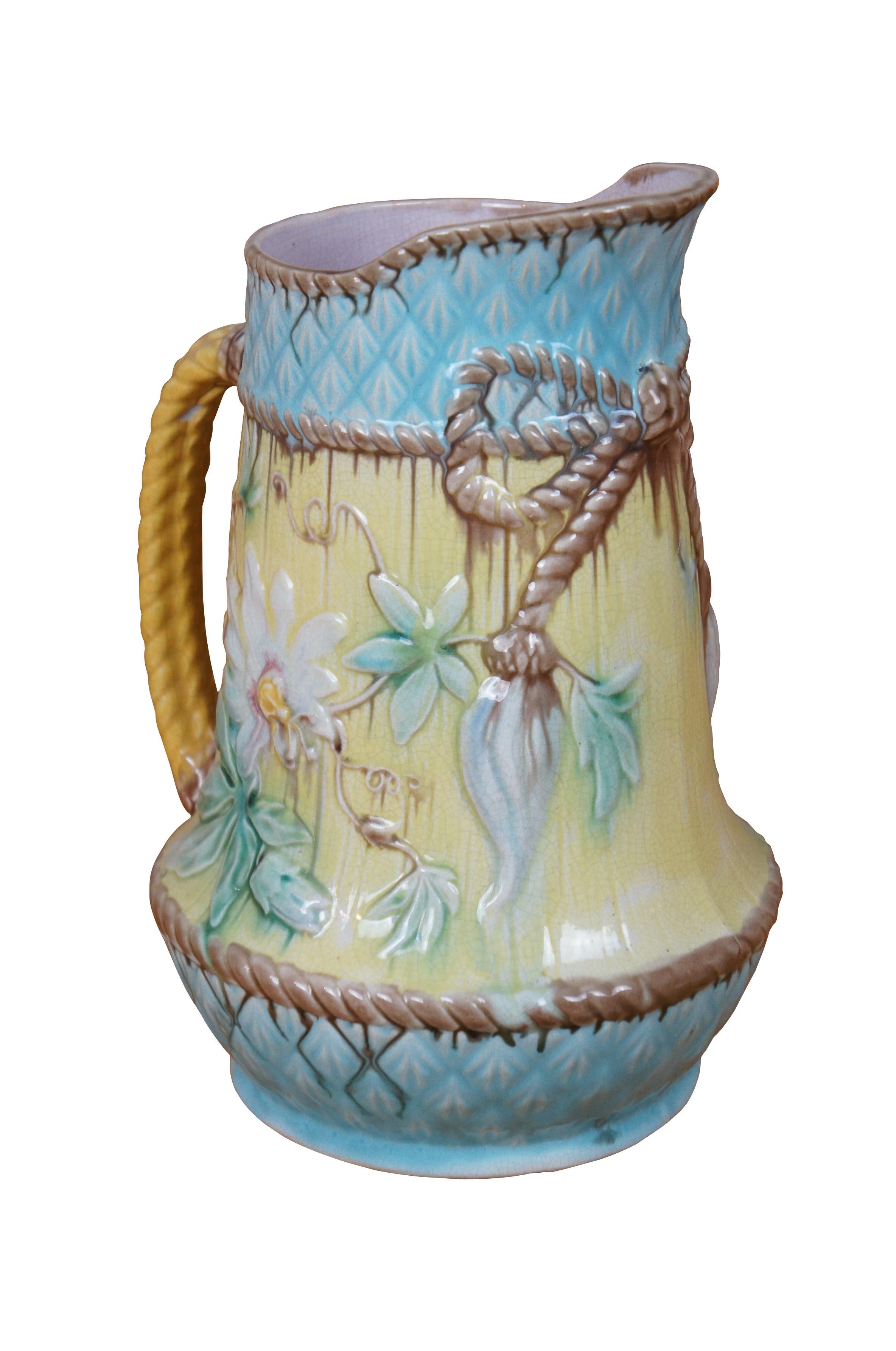 Brocca/tazza antica in maiolica francese molto grande e imponente, con un disegno di ananas blu turchese e giallo con fiori della Passione, con bordo e manico in corda e interno color lavanda.  Attribuito a Wardle.

Dimensioni:
7,75