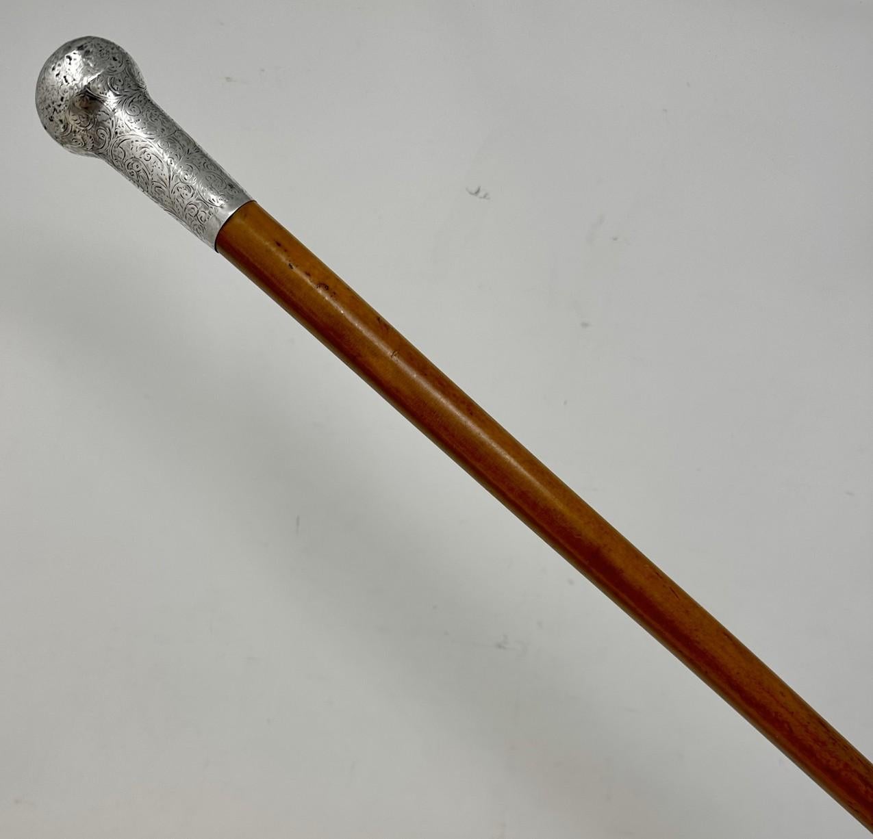 Fine Quality French Polished Heavy Gauge Blonde Malacca Walking Cane with Highly Decorative Embossed Silver Grip, made by renowned English Stick Maker Charles Feldman.  

The circular silver knopped grip above a tapering turned Malacca tapering