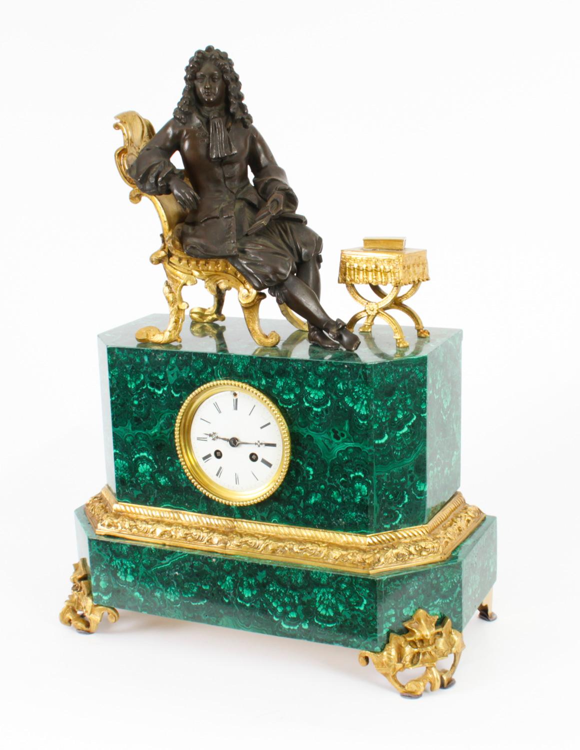 This is a superb quality antique French malachite, bronze and ormolu mantel clock dating from Circa 1850 in date.

It features Louis XVI seated on an ormolu throne chair whilst reading a book.

The clockmakers name is inscribed on the backplate.