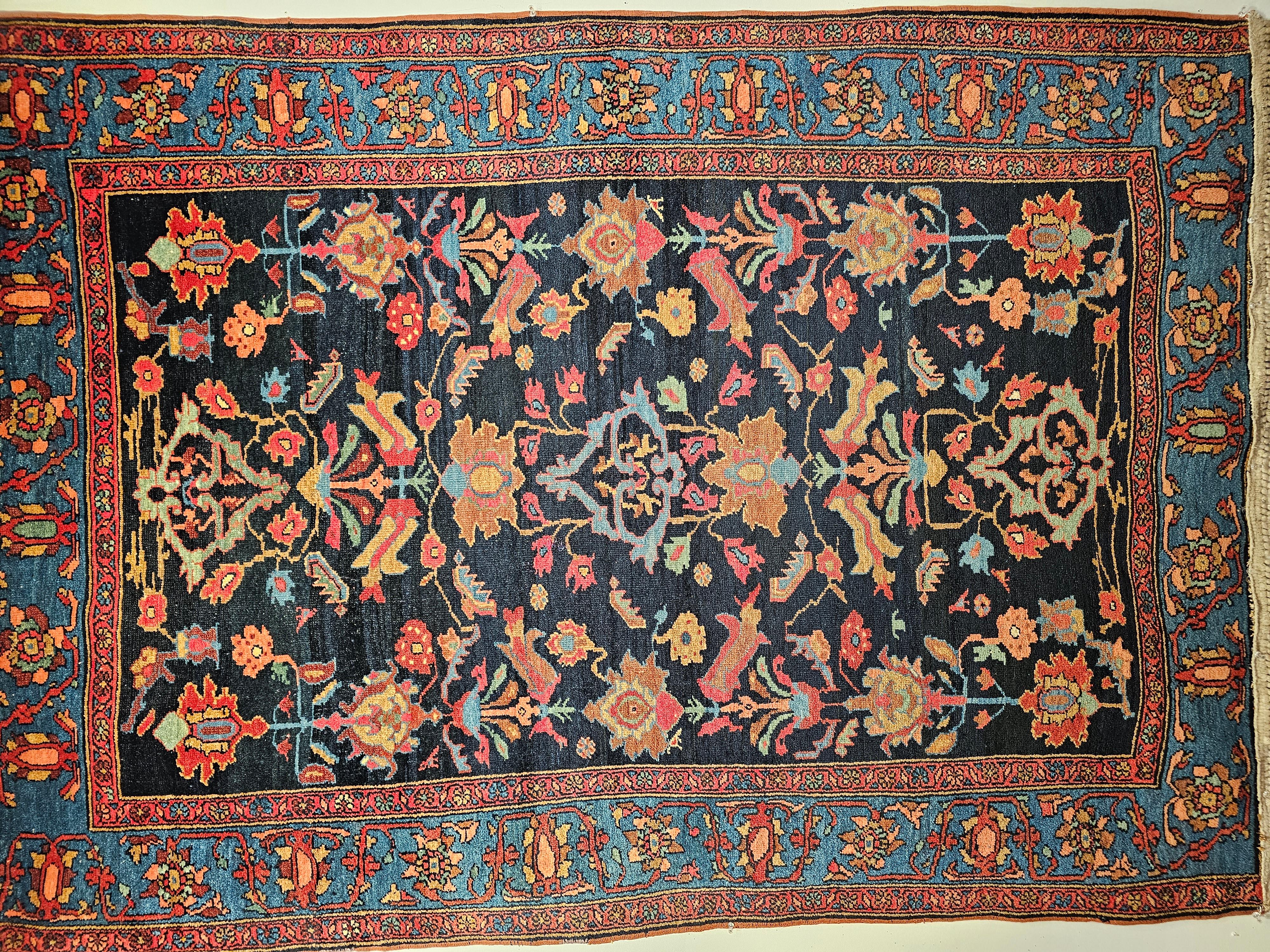 Vintage Persian Malayer area rug in an allover geometric pattern set on a midnight blue background with a French blue border and accents colors in pink, yellow, green, and red circa the early 1900s.    The larger format design elements in the field