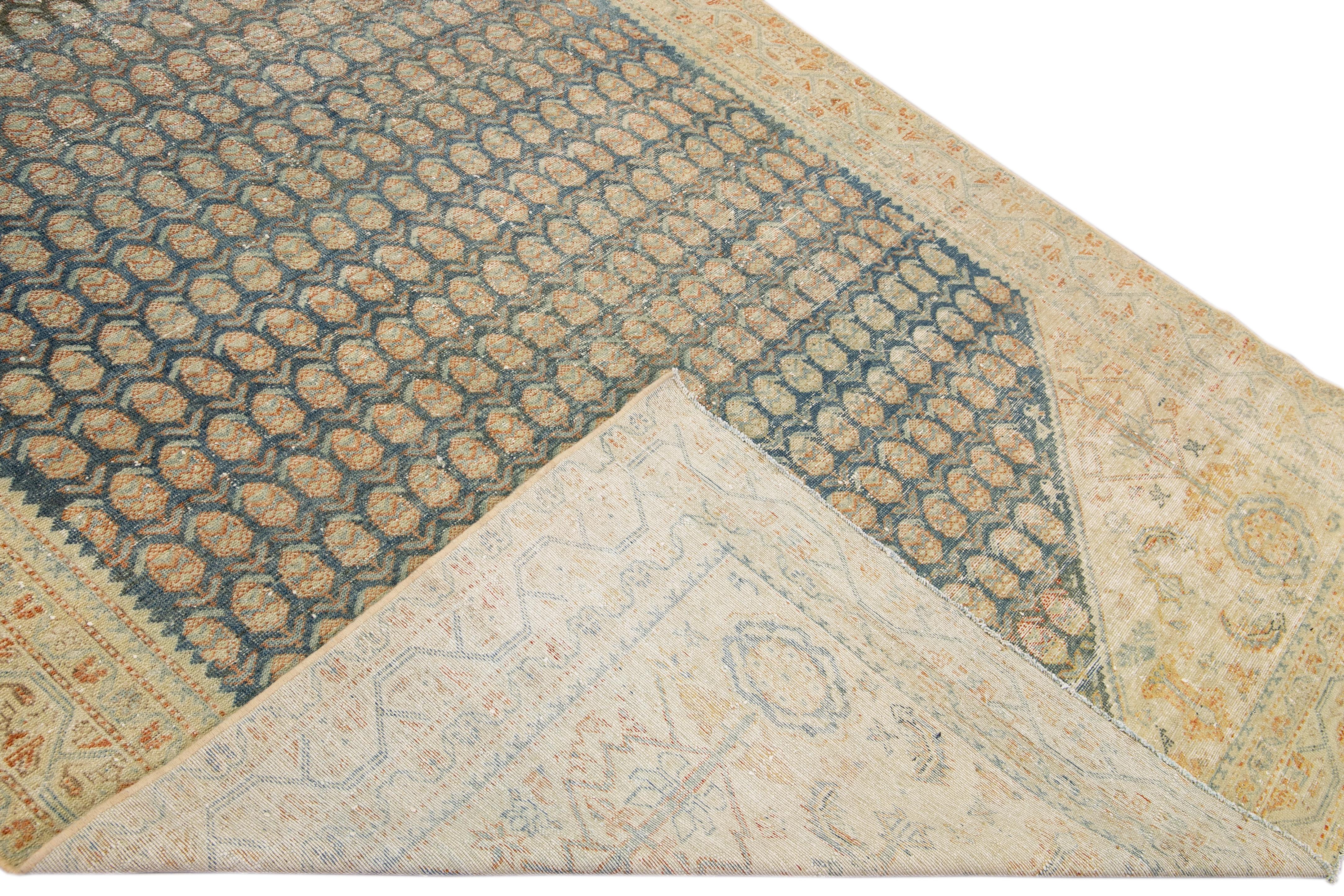 Beautiful antique Malayer hand-knotted wool rug with a beige and blue field. This Malayer piece has an orange accent in a gorgeous all-over palmette pattern design.

This rug measures: 6'8