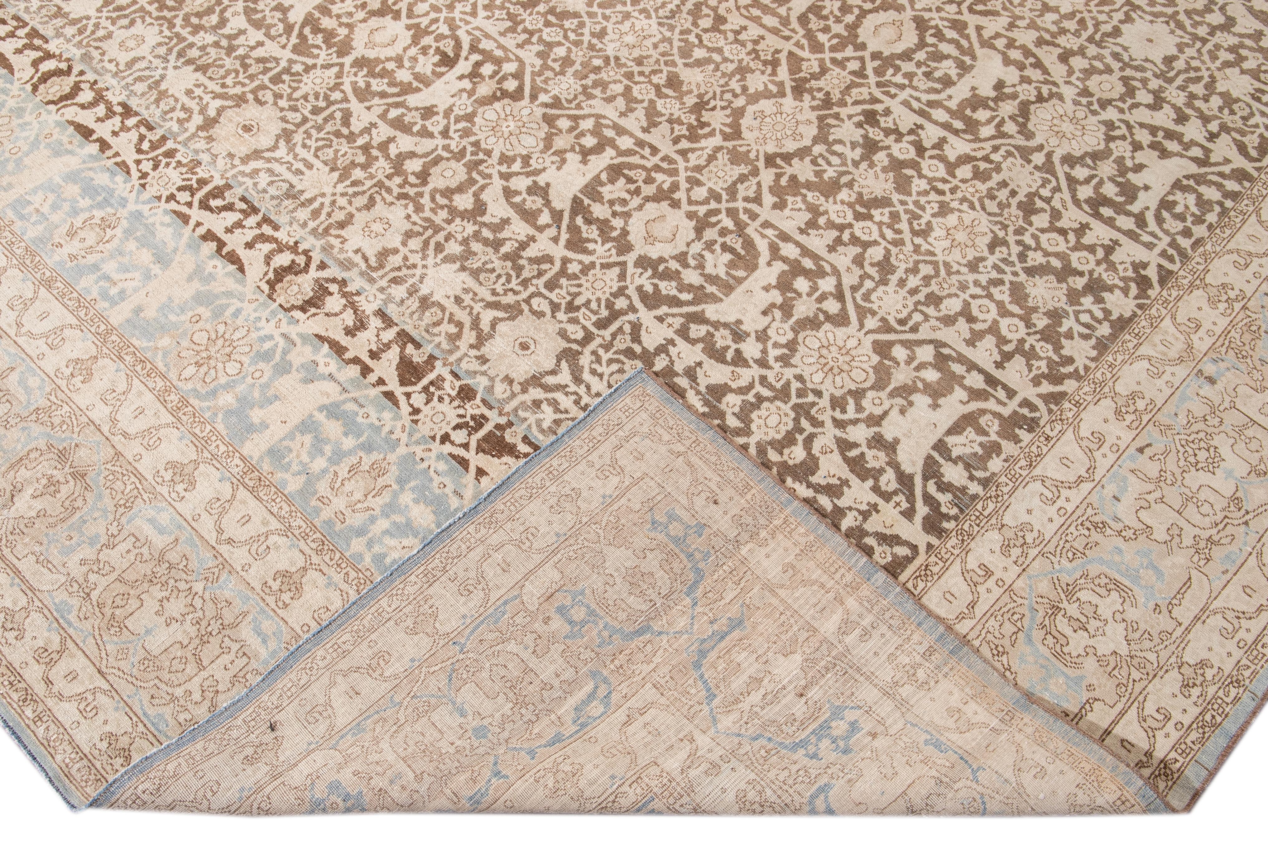 Beautiful antique Malayer hand-knotted wool rug with a brown field. This Malayer piece has a beige frame and blue accents in a gorgeous all-over floral pattern design.

This rug measures: 10'4