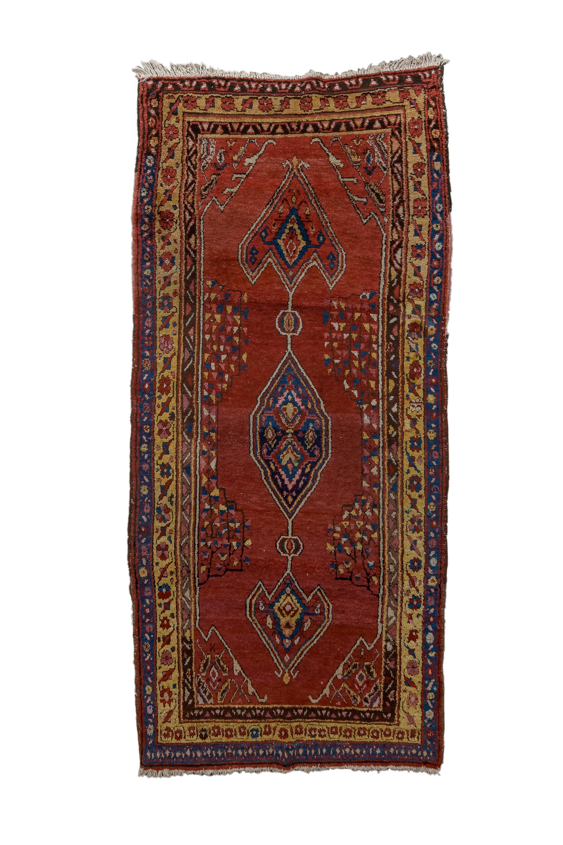 This ebulliently coloured kellegi (long rug) shows a tripartite pole medallion with a small hexagonal centre and giant anchor finials, on a shaped, brisk red field  with lateral partial triangle mosaics.  Goldenrod main border with rosettes and