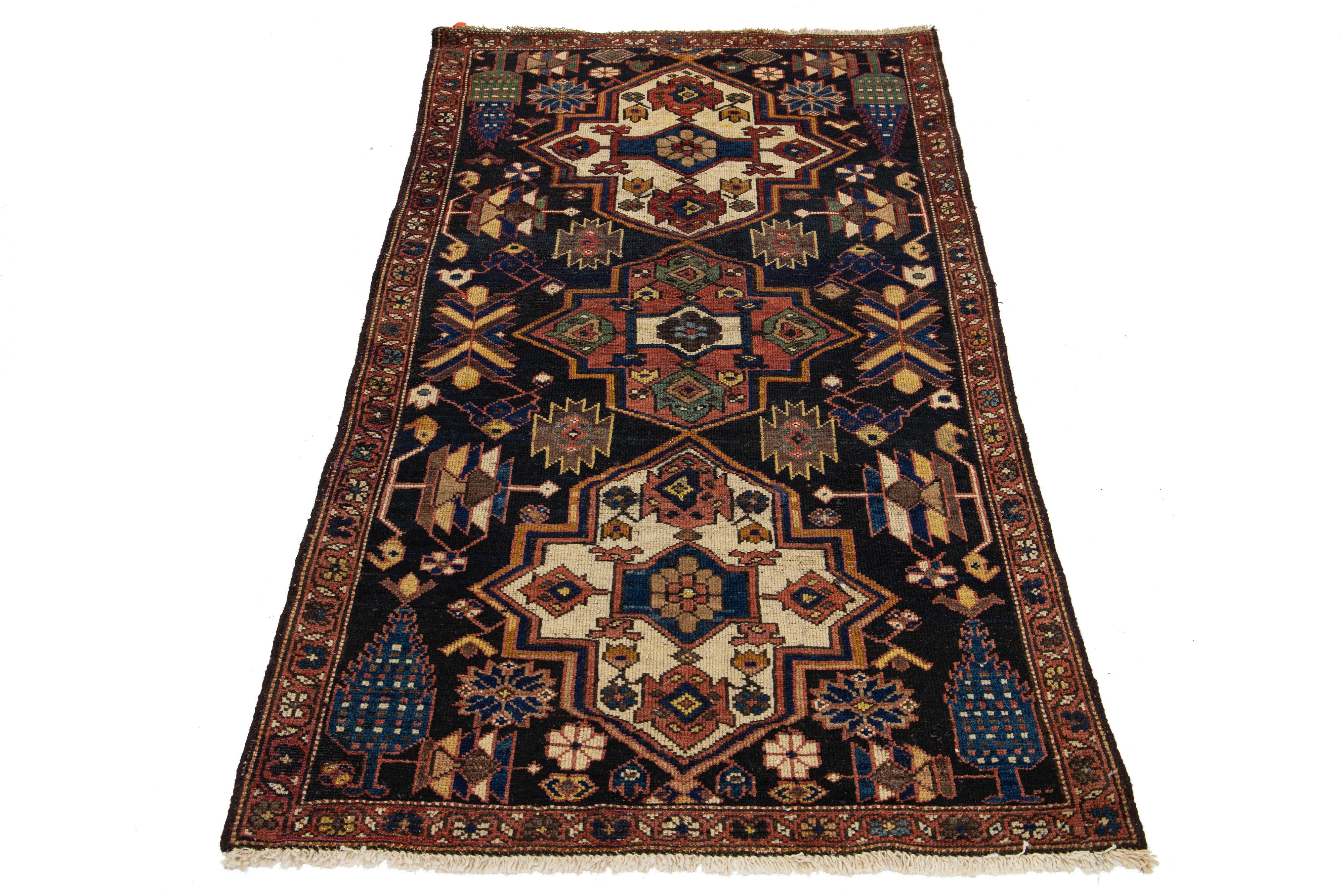 Ce tapis persan Malayer, fait à la main, date du 20e siècle. Son motif géométrique présente un champ bleu orné d'accents multicolores.

Ce tapis mesure 3'4