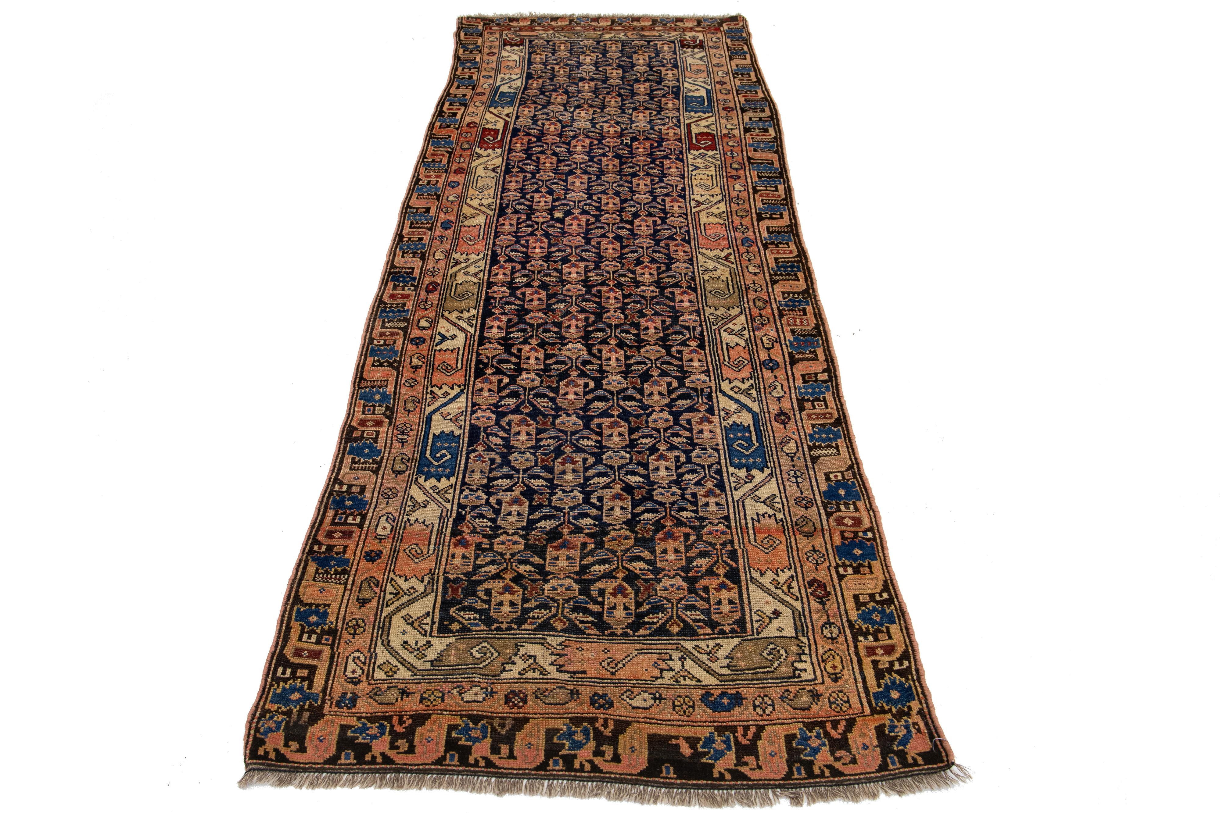 Il s'agit d'un tapis persan Malayer fait à la main et datant du 20e siècle. Il présente un champ bleu foncé avec des accents pêche et beige sur l'ensemble du motif Boteh.

Ce tapis mesure 3'6