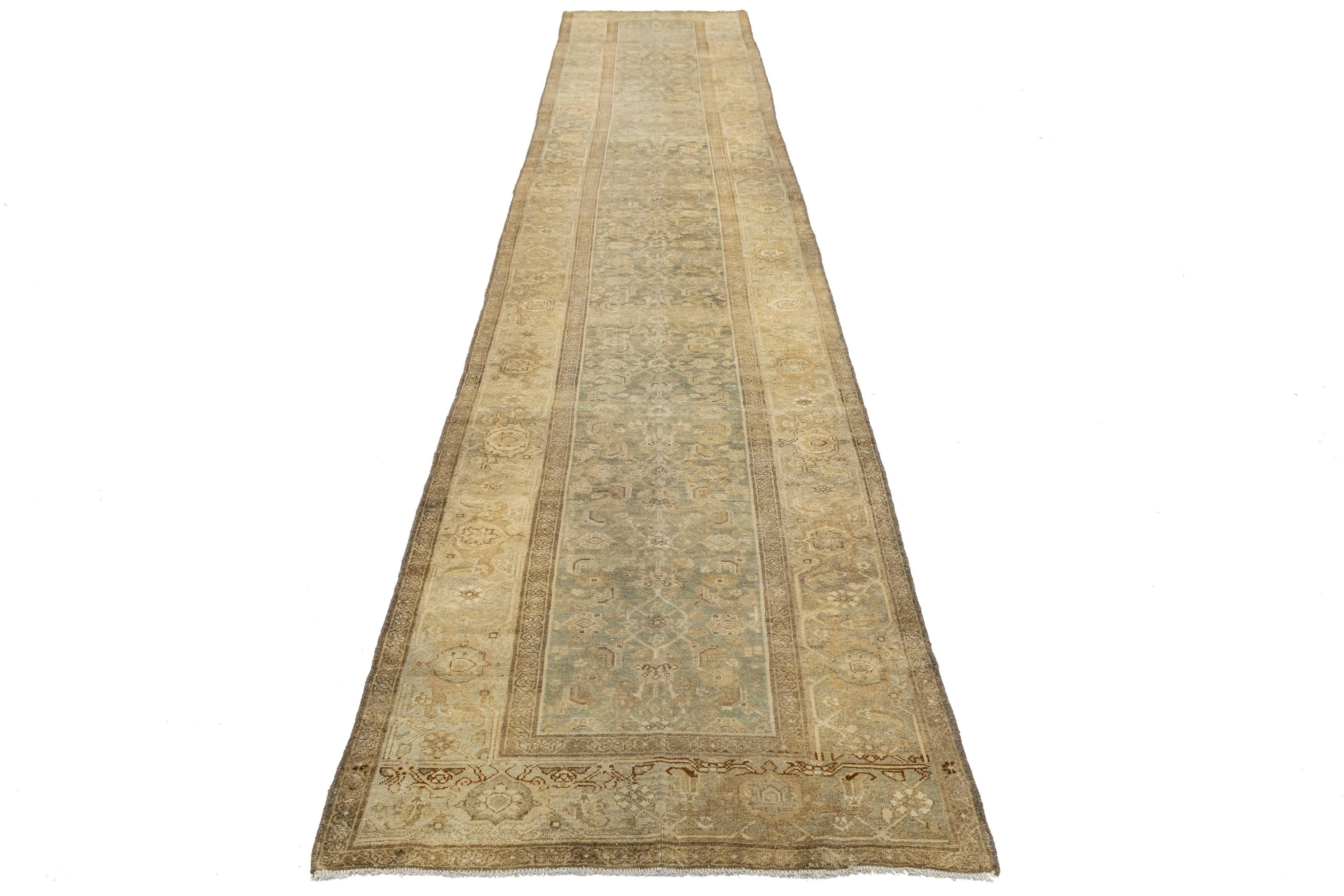 Antico tappeto persiano in lana Malayer con campo blu e beige sbiadito, caratterizzato da delicati motivi floreali e geometrici. Il suo formato allungato e la patina consumata evidenziano l'artigianato del villaggio e la sobria eleganza dell'Iran