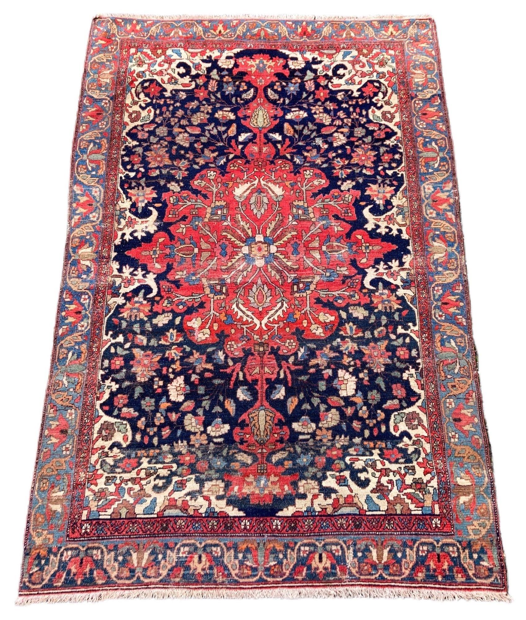 Ein schöner antiker Malayer-Teppich, handgewebt in Westpersien um 1900 mit einem großen tomatenroten Medaillon auf einem indigoblauen Feld und einer helleren blauen Bordüre. Es hat zwar irgendwo auf seiner Reise seine äußere Umrandung verloren, aber