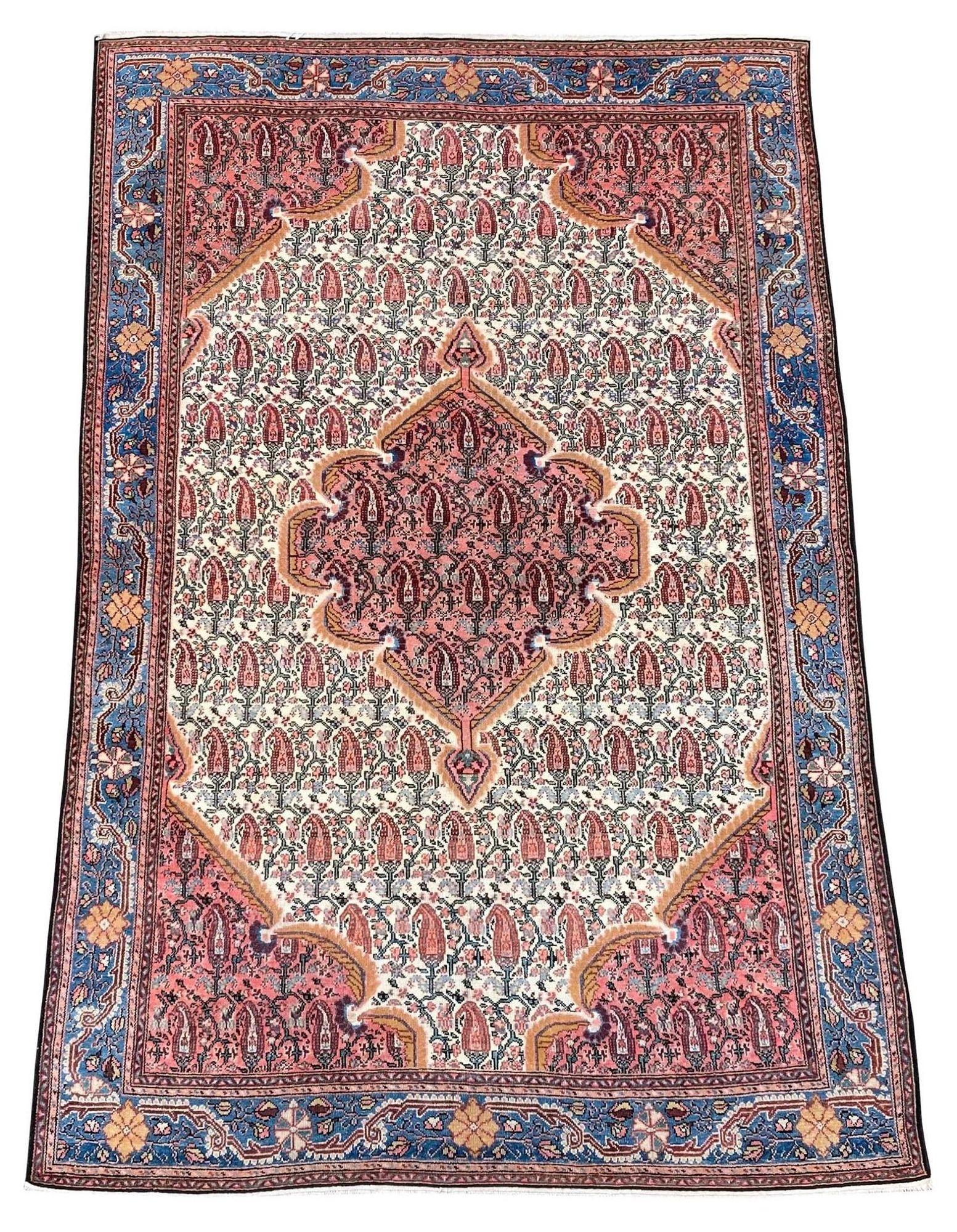 A lovely antique Malayer rug, handwoven circa 1900 with a linked Boteh medallion on an ivory field and attractive light blue border. Very finely woven with high quality wool and great secondary colours, particularly the combination of pink and