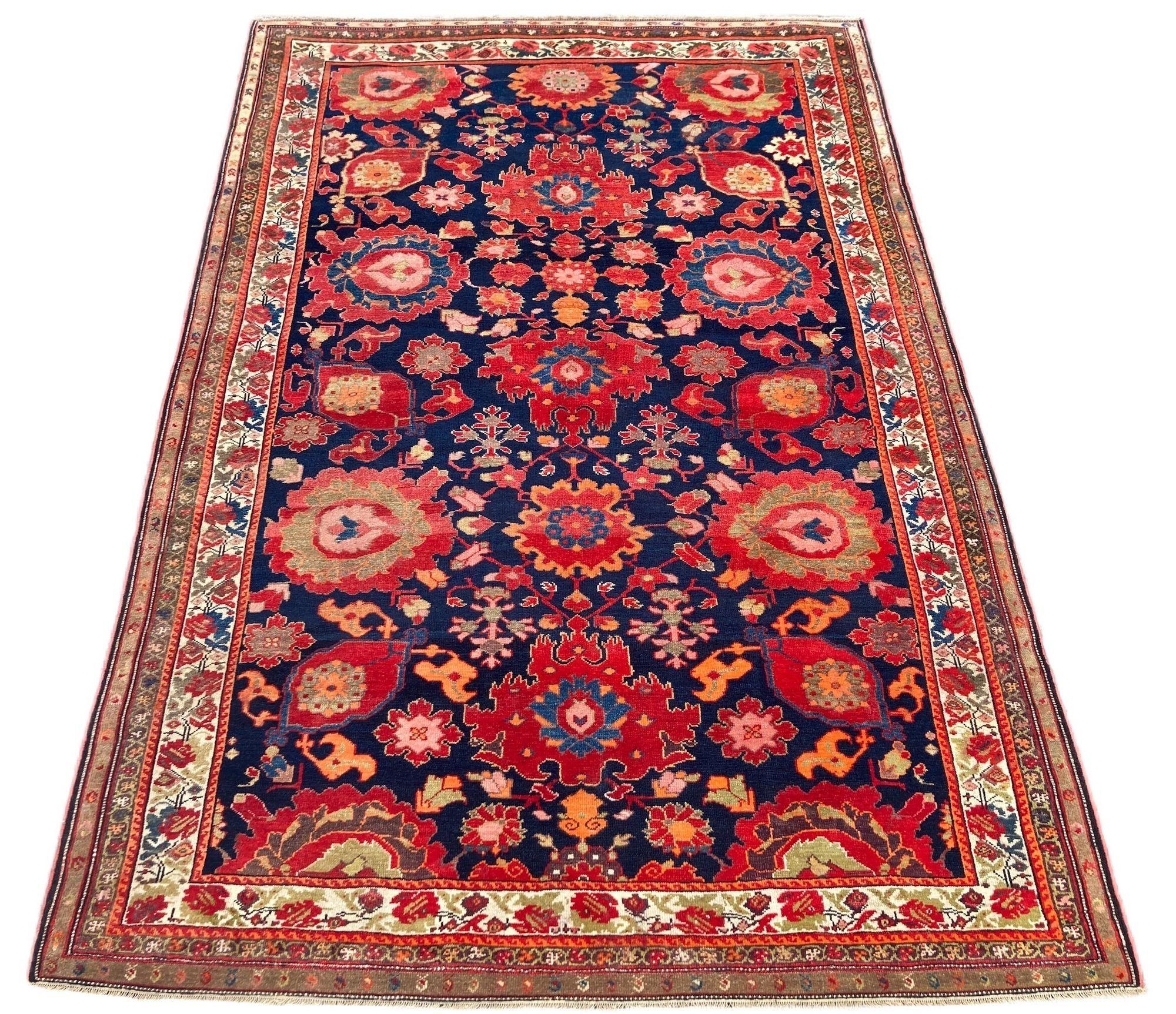 An exceptional antique Malayer rug, hand woven circa 1900. The design features an allover design of large palmettes on a deep indigo field and small ivory border decorated with roses. Fabulous secondary colours including pinks and greens and a