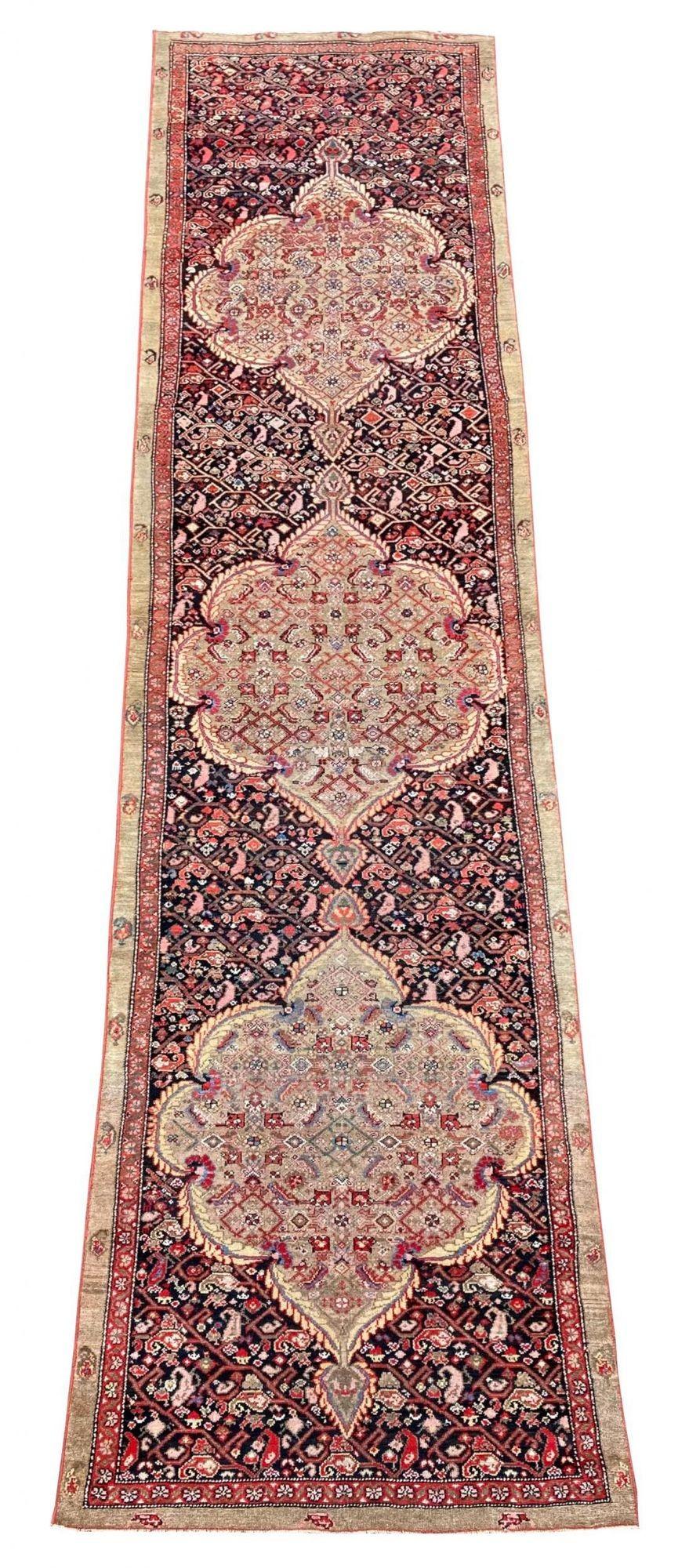 An outstanding antique Malayer runner, handwoven circa 1900. The design features three large pistachio green Herati medallions on a deep indigo field of linked Botehs. Lovely wool quality and great secondary colours.

Size: 4.25m x 0.96m (13ft 11in