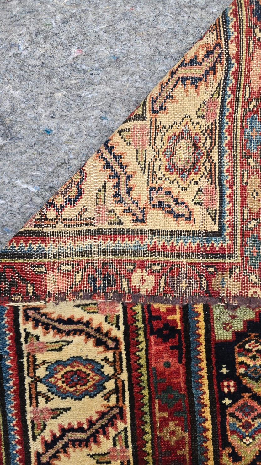 Il tappeto presenta un ricco disegno Boteh, meticolosamente dettagliato in blu intenso, rosso e avorio. L'elegante disegno del pennacchio nella parte superiore conduce a un arco di preghiera angolare, che aumenta il fascino simbolico e decorativo